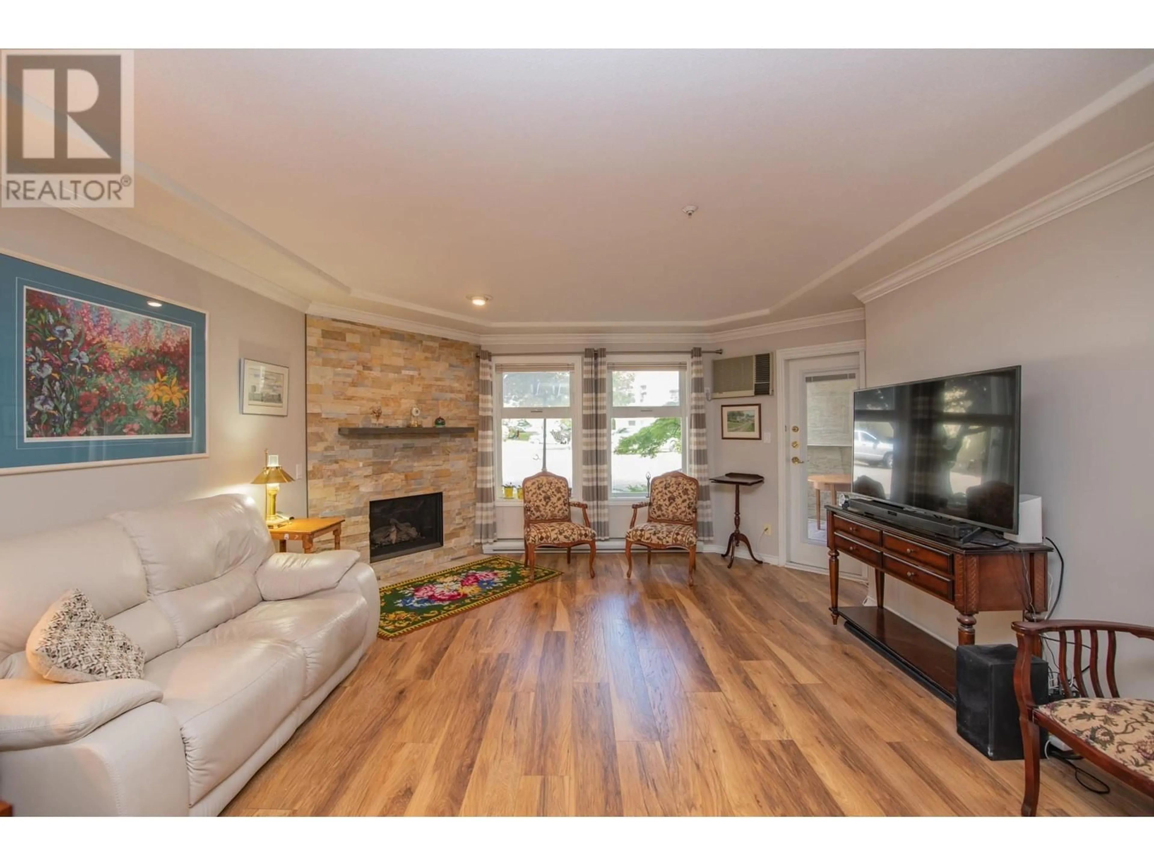 Living room with furniture, wood/laminate floor for 102 - 3300 CENTENNIAL DRIVE, Vernon British Columbia V1T9M5