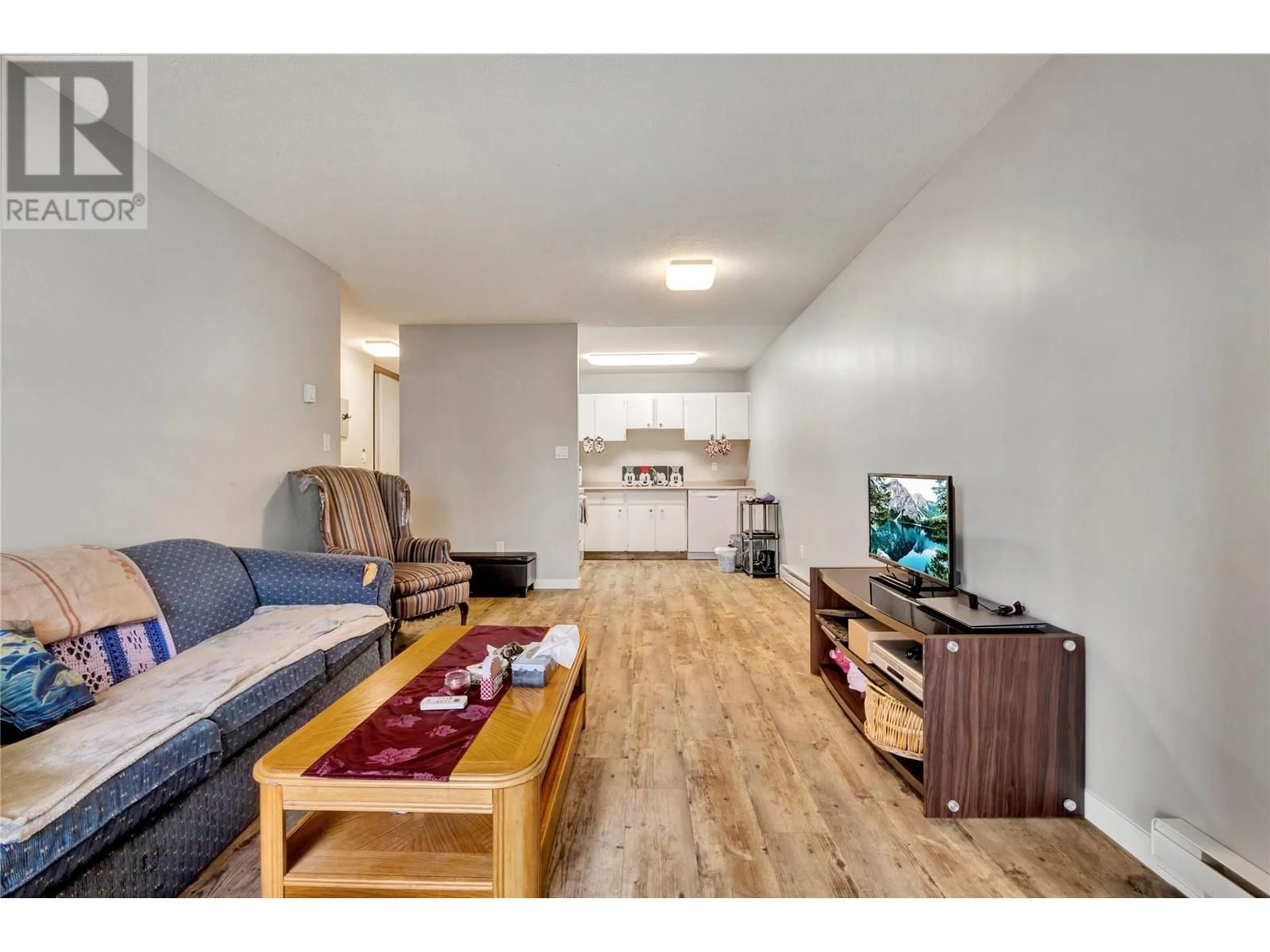 Living room with furniture, wood/laminate floor for 107 - 395 FRANKLYN ROAD, Kelowna British Columbia V1X5X8