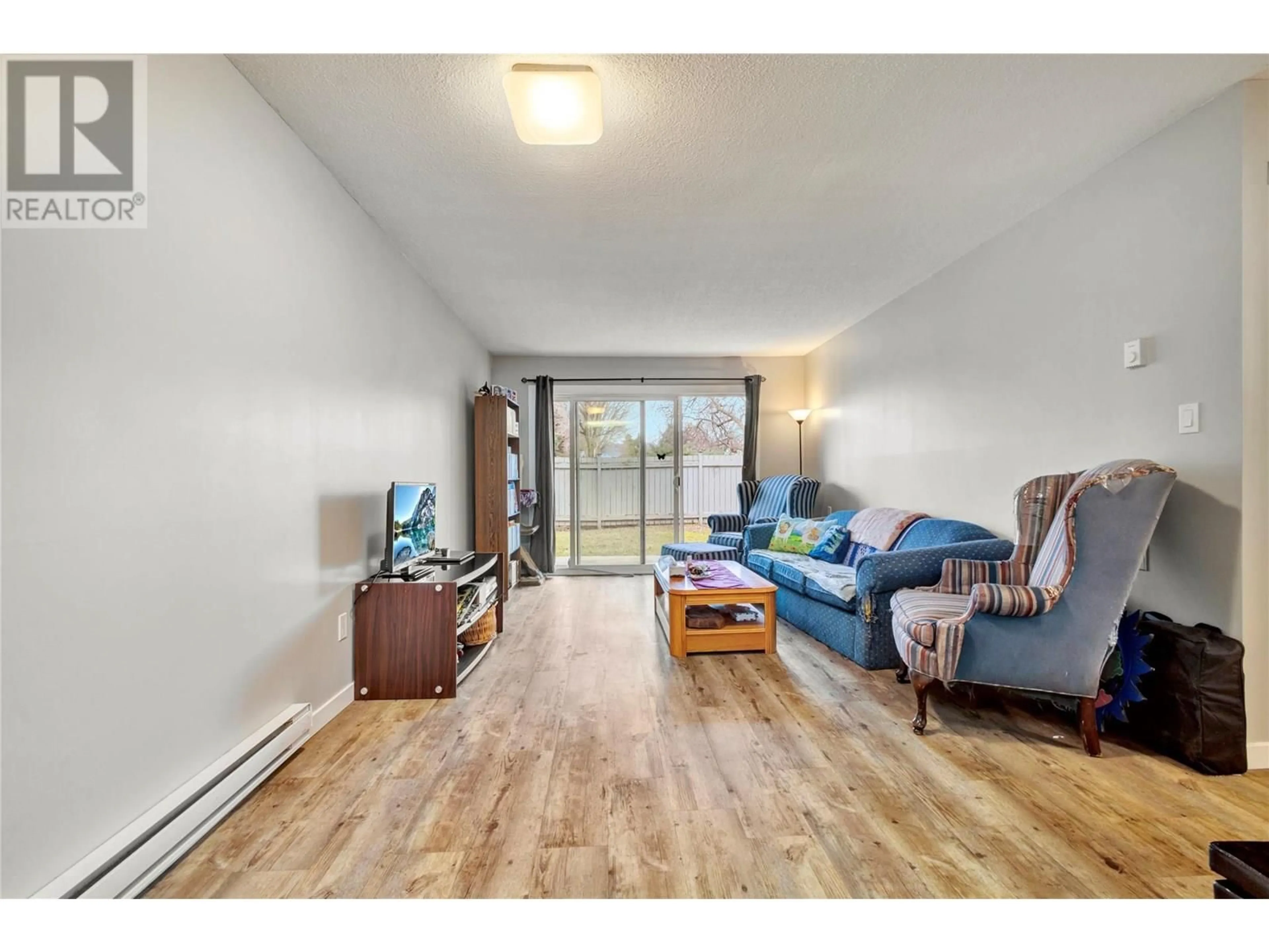 Living room with furniture, wood/laminate floor for 107 - 395 FRANKLYN ROAD, Kelowna British Columbia V1X5X8