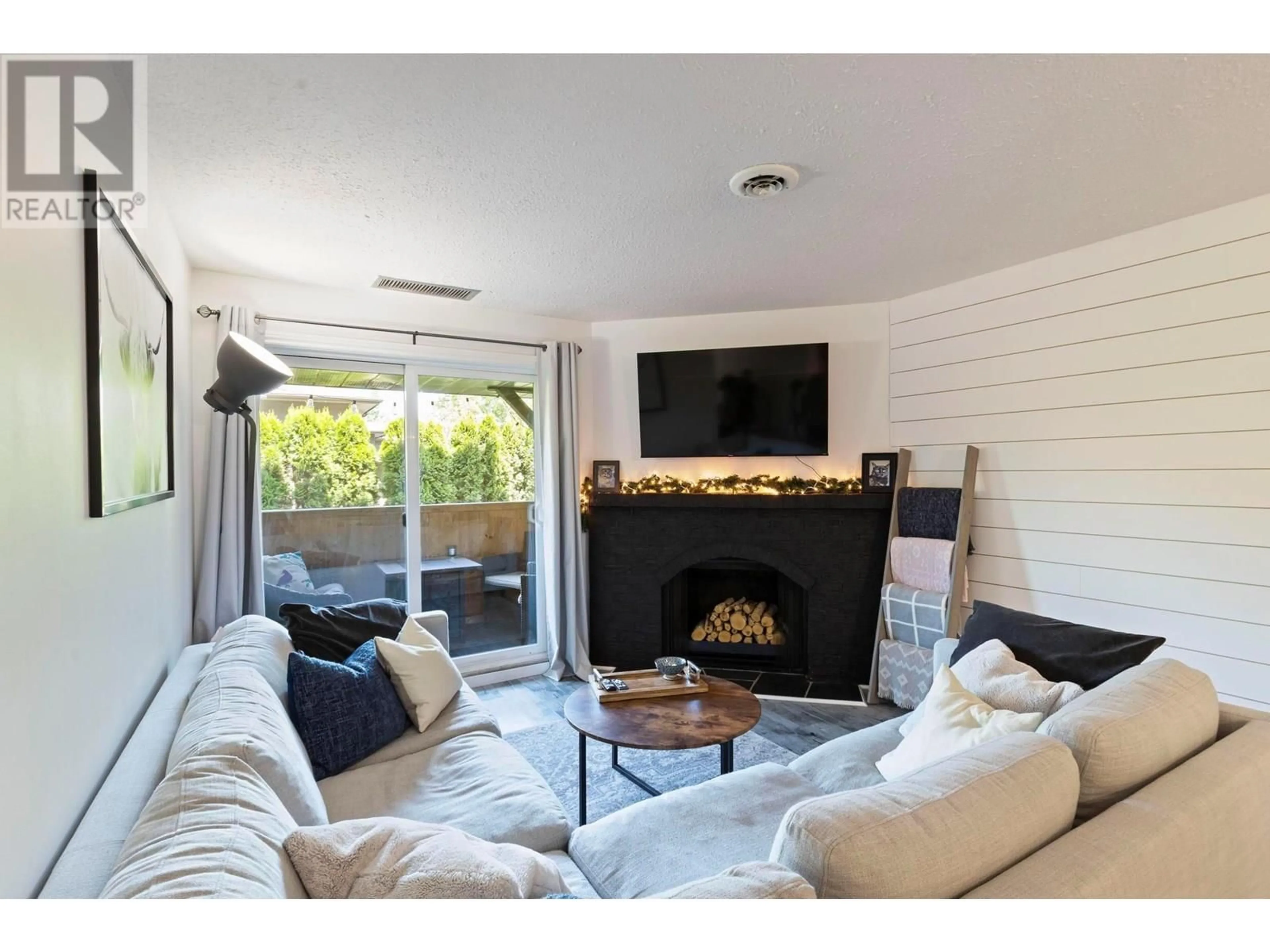 Living room with furniture, wood/laminate floor for 104 - 1665 UFTON COURT, Kelowna British Columbia V1Y8G7