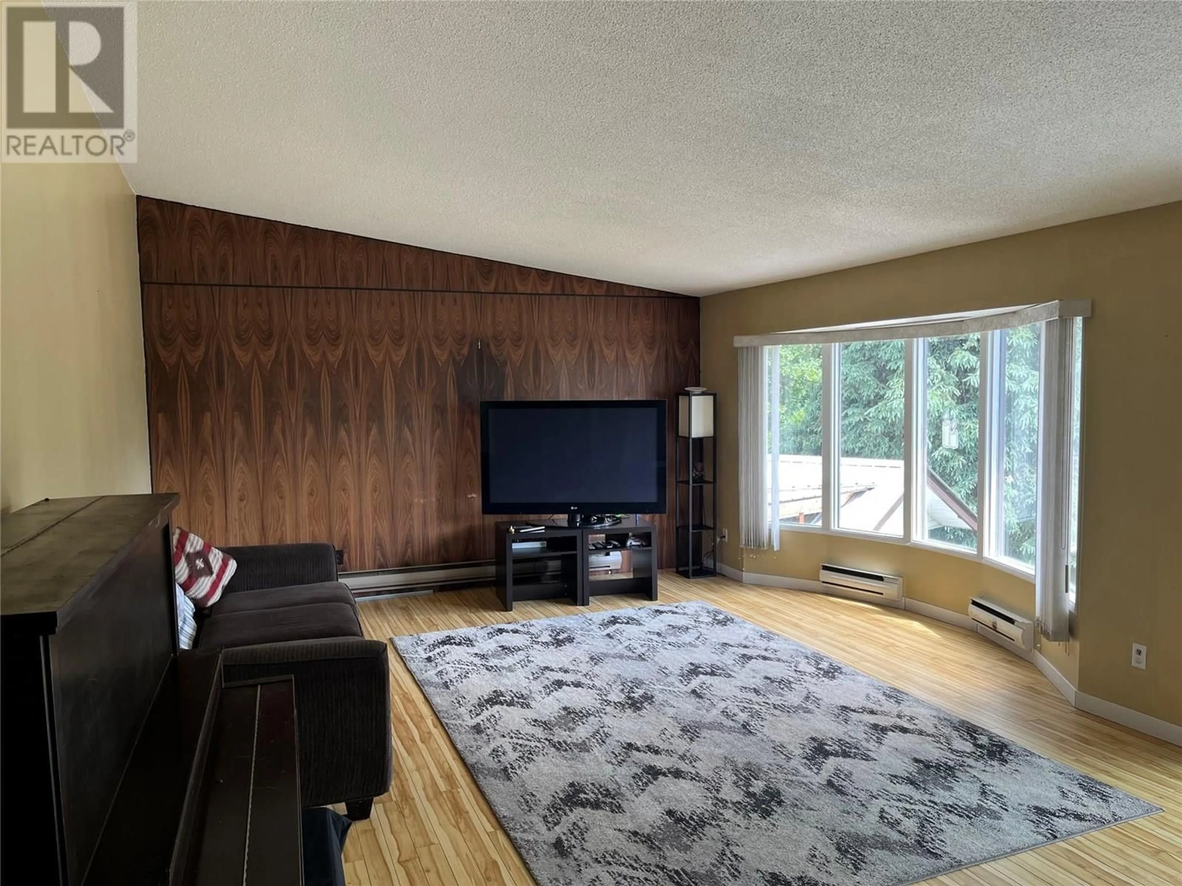 Living room with furniture, wood/laminate floor for 801 LYNNWOOD CRESCENT, Castlegar British Columbia V1N1E5