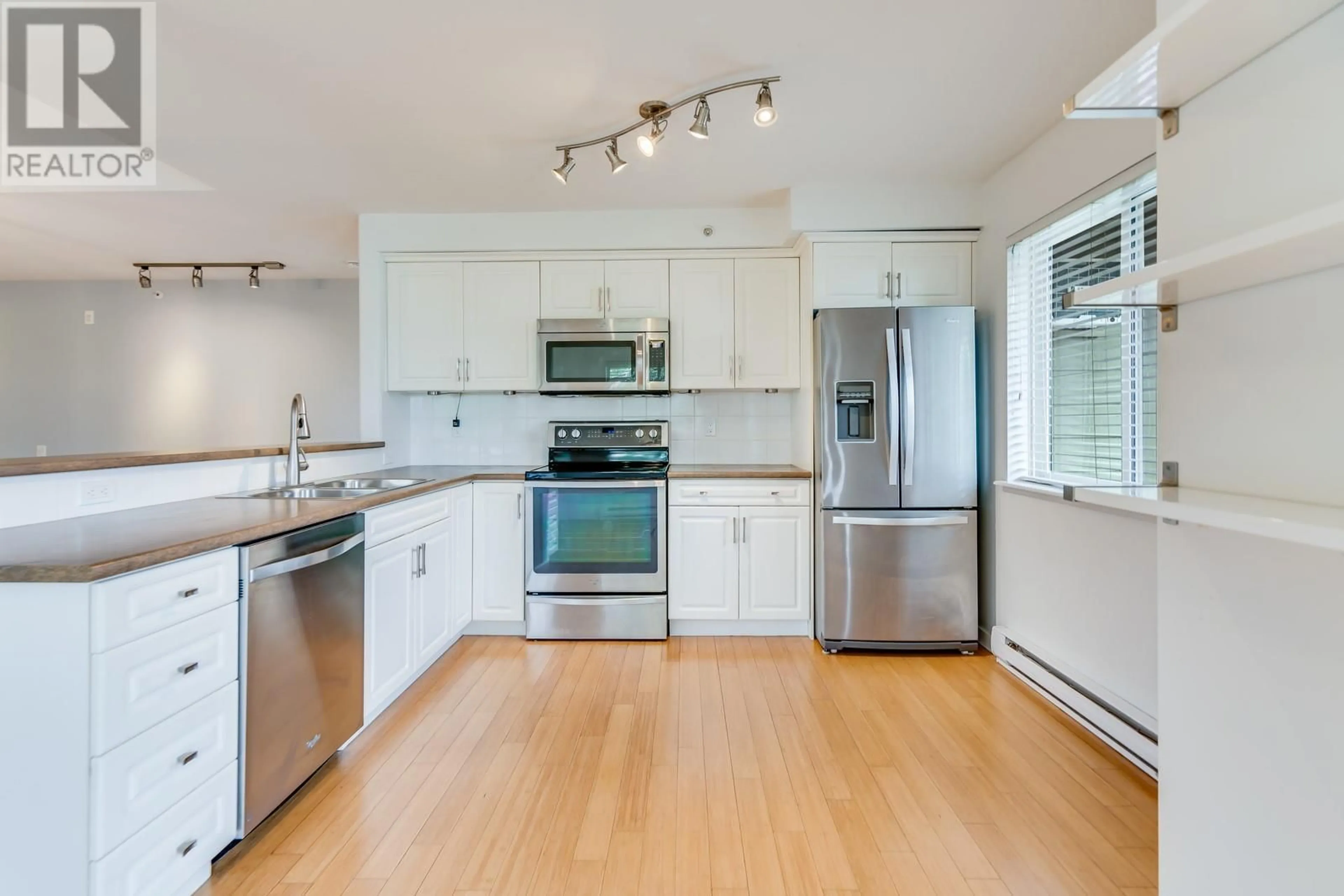 Open concept kitchen, wood/laminate floor for 409 - 686 LEQUIME ROAD, Kelowna British Columbia V1W1A4