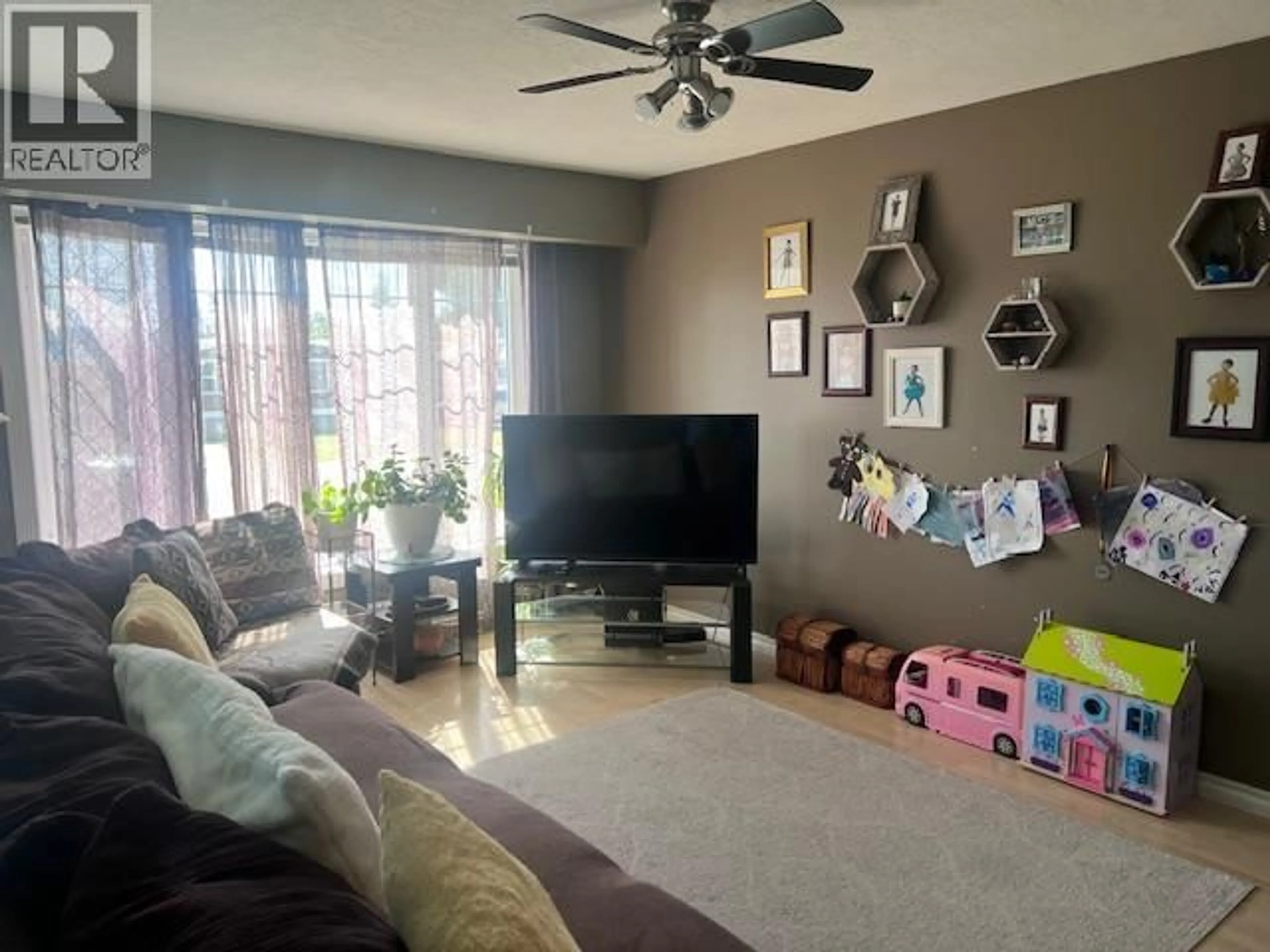 Living room with furniture, wood/laminate floor for 312 99 AVENUE, Dawson Creek British Columbia V1G1S9