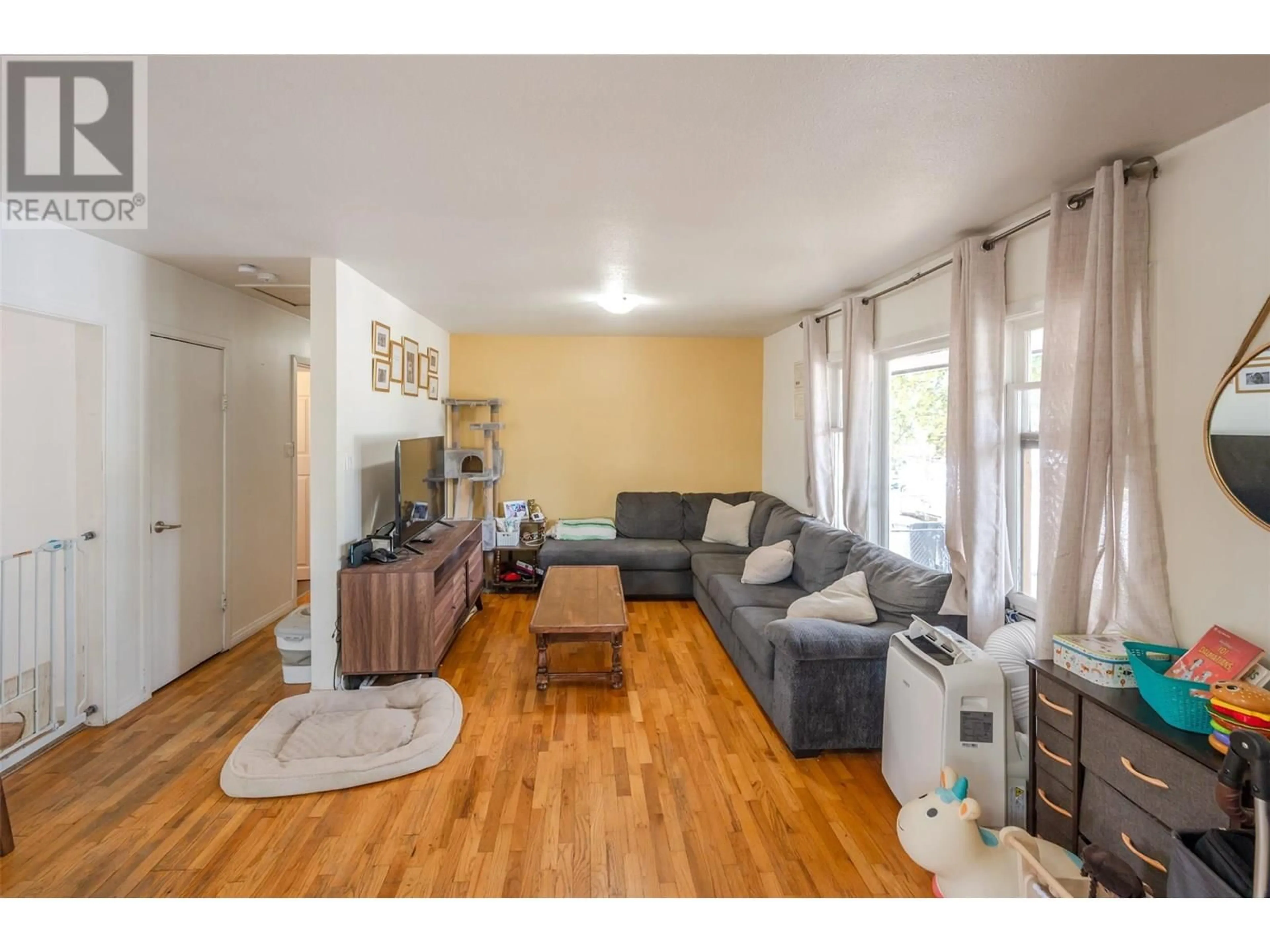 Living room with furniture, wood/laminate floor for 496 PAPINEAU STREET, Penticton British Columbia V2A4X5