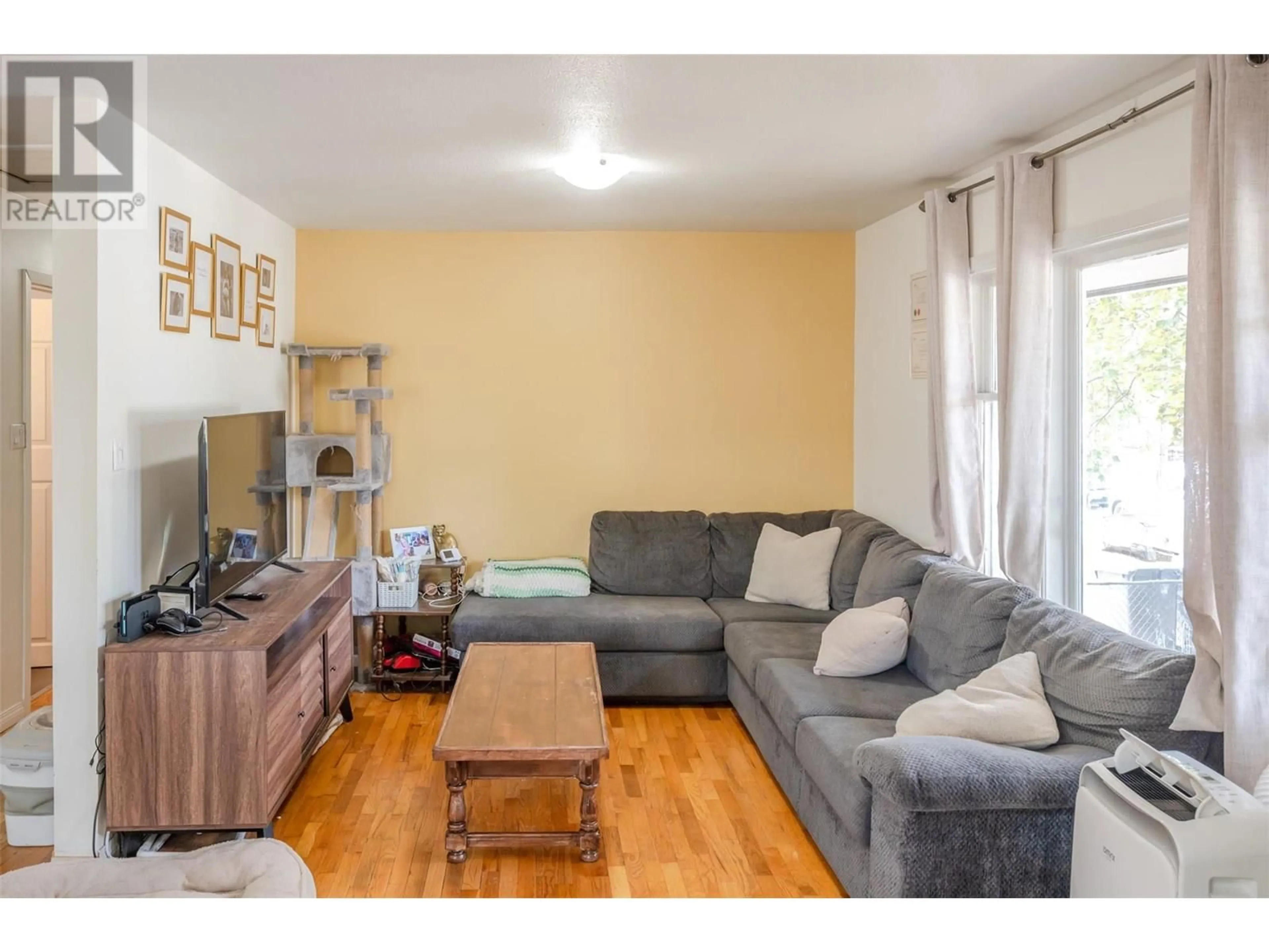 Living room with furniture, wood/laminate floor for 496 PAPINEAU STREET, Penticton British Columbia V2A4X5