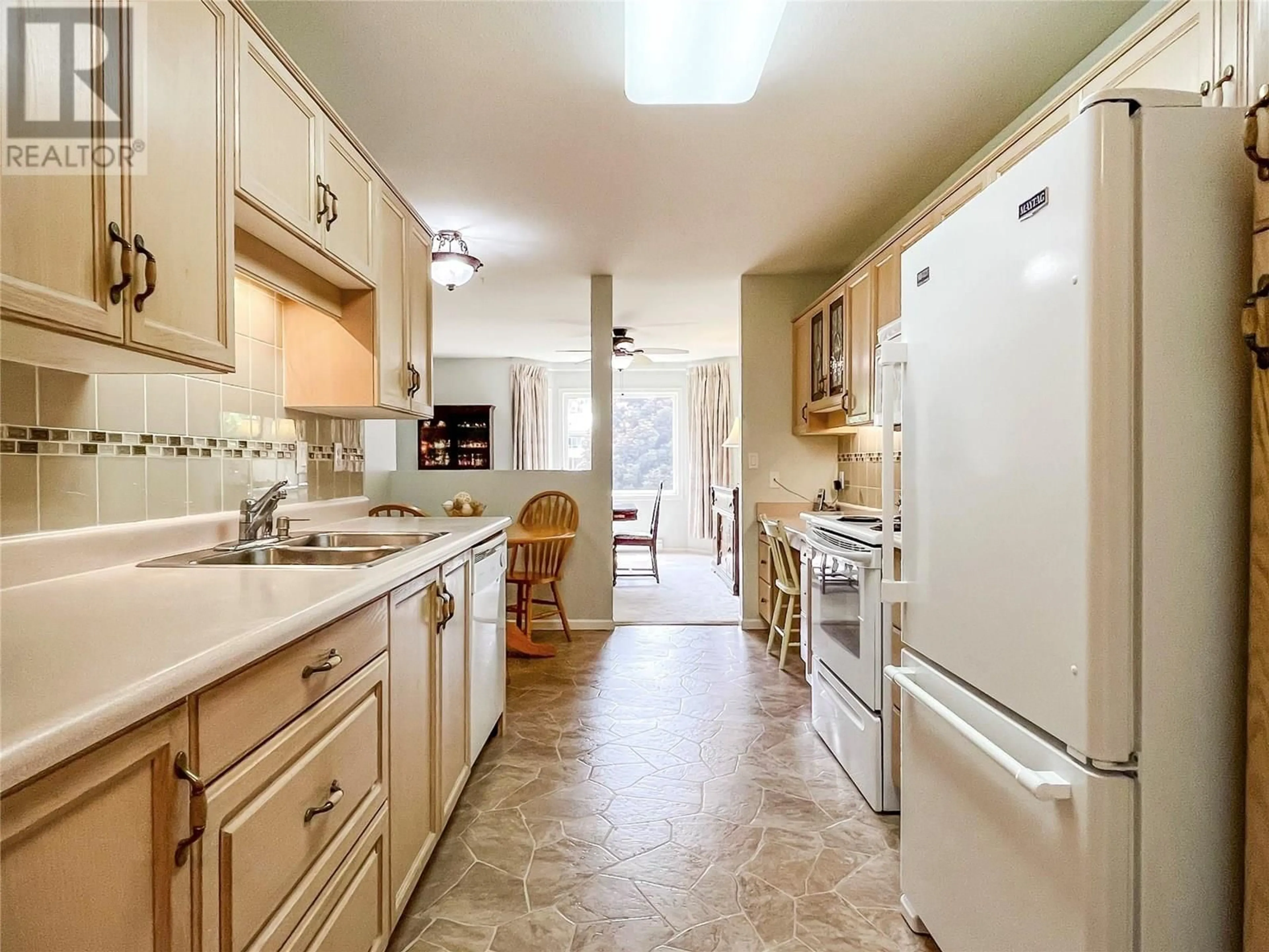 Kitchen with laundary machines, ceramic/tile floor for 202 - 8905 PINEO COURT, Summerland British Columbia V0H1Z5