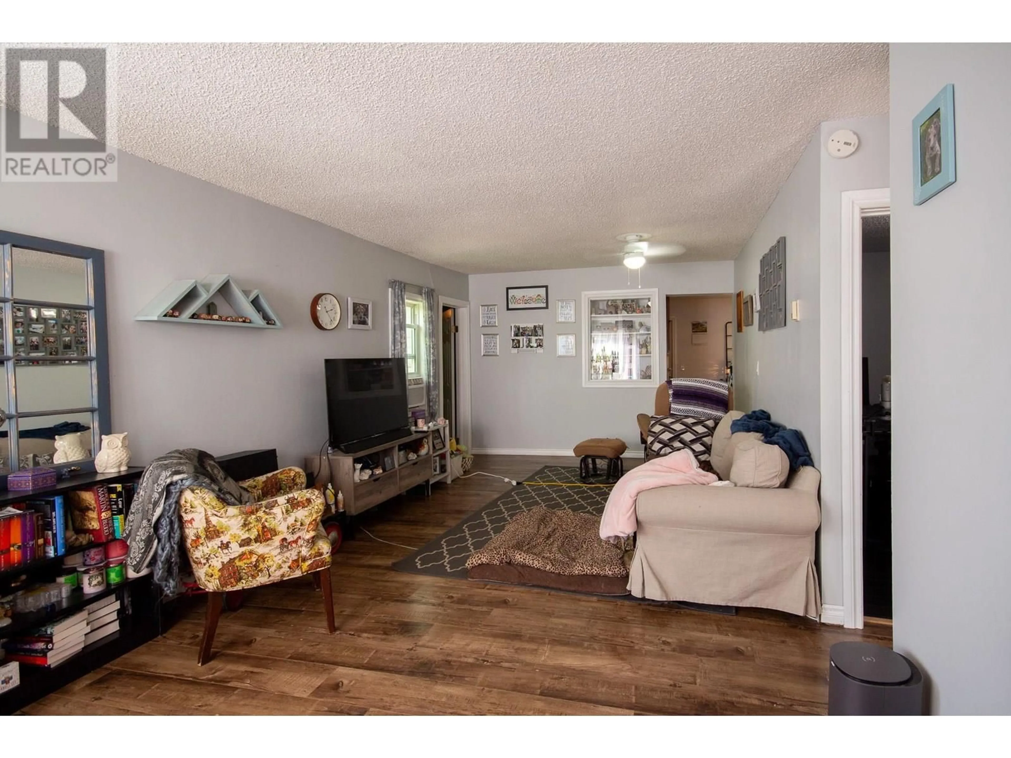 Living room with furniture, wood/laminate floor for 1120 104 AVENUE, Dawson Creek British Columbia V1G2J2