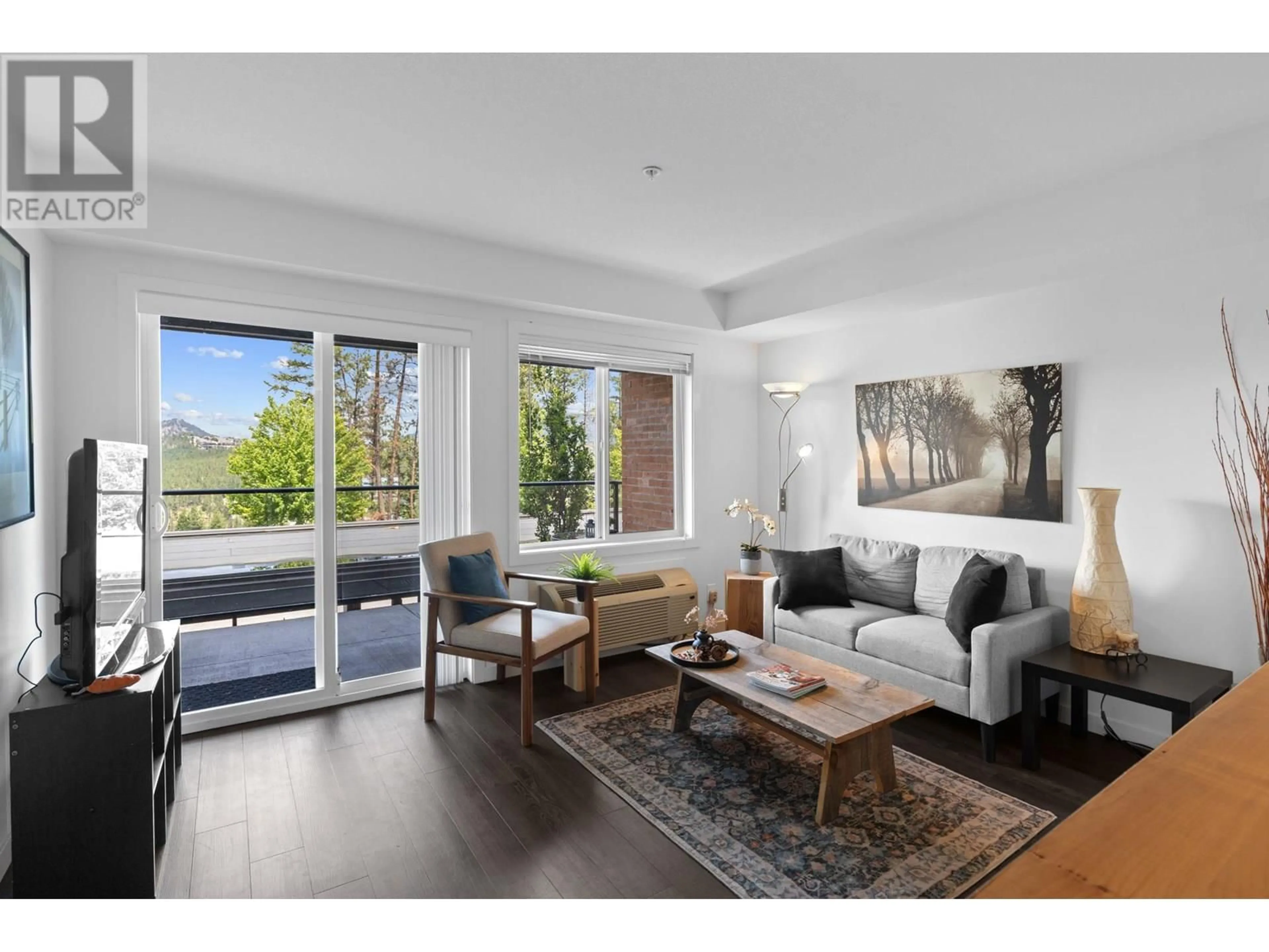 Living room with furniture, wood/laminate floor for 103 - 881 ACADEMY WAY, Kelowna British Columbia V1V0A2