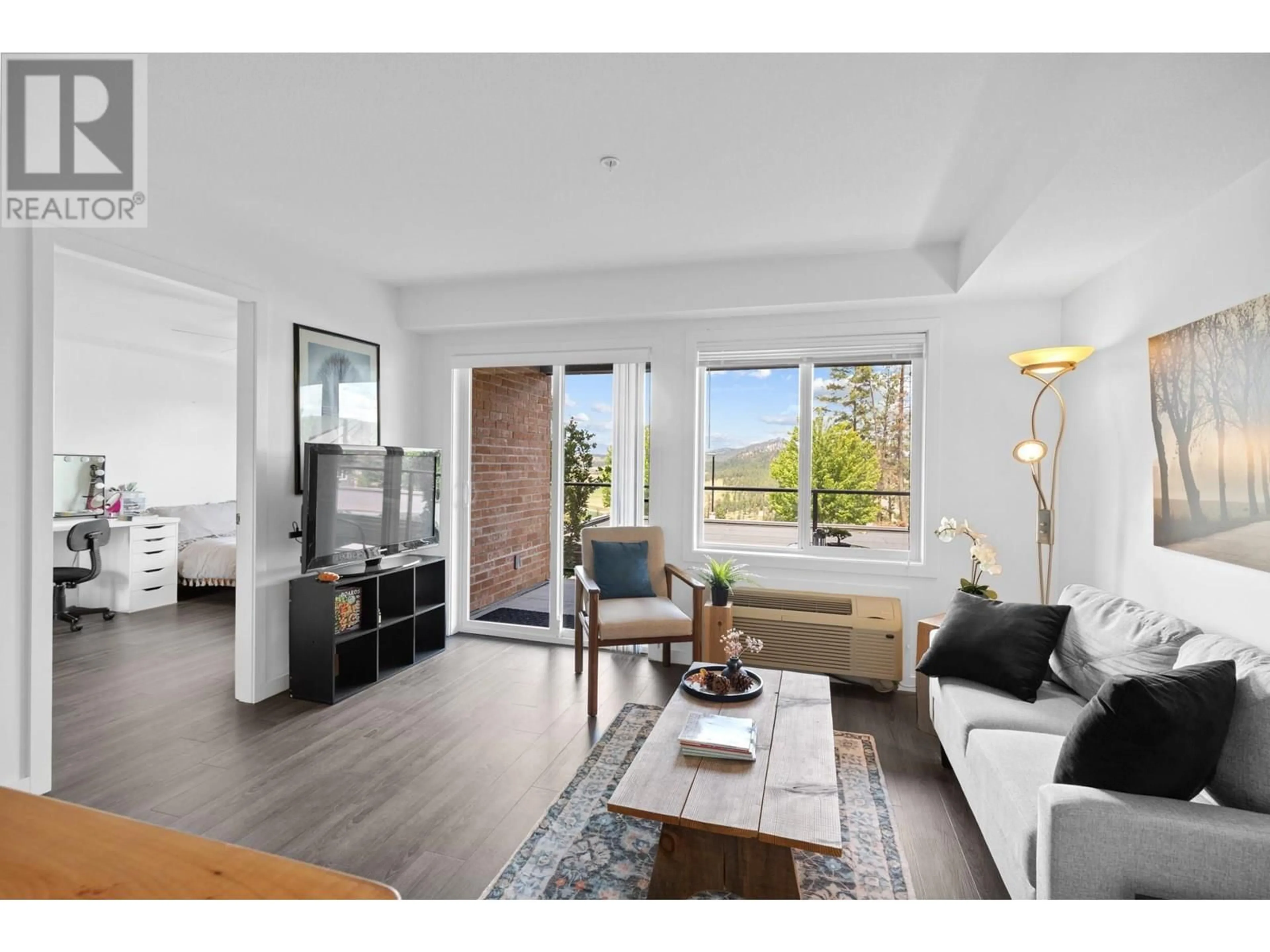 Living room with furniture, wood/laminate floor for 103 - 881 ACADEMY WAY, Kelowna British Columbia V1V0A2