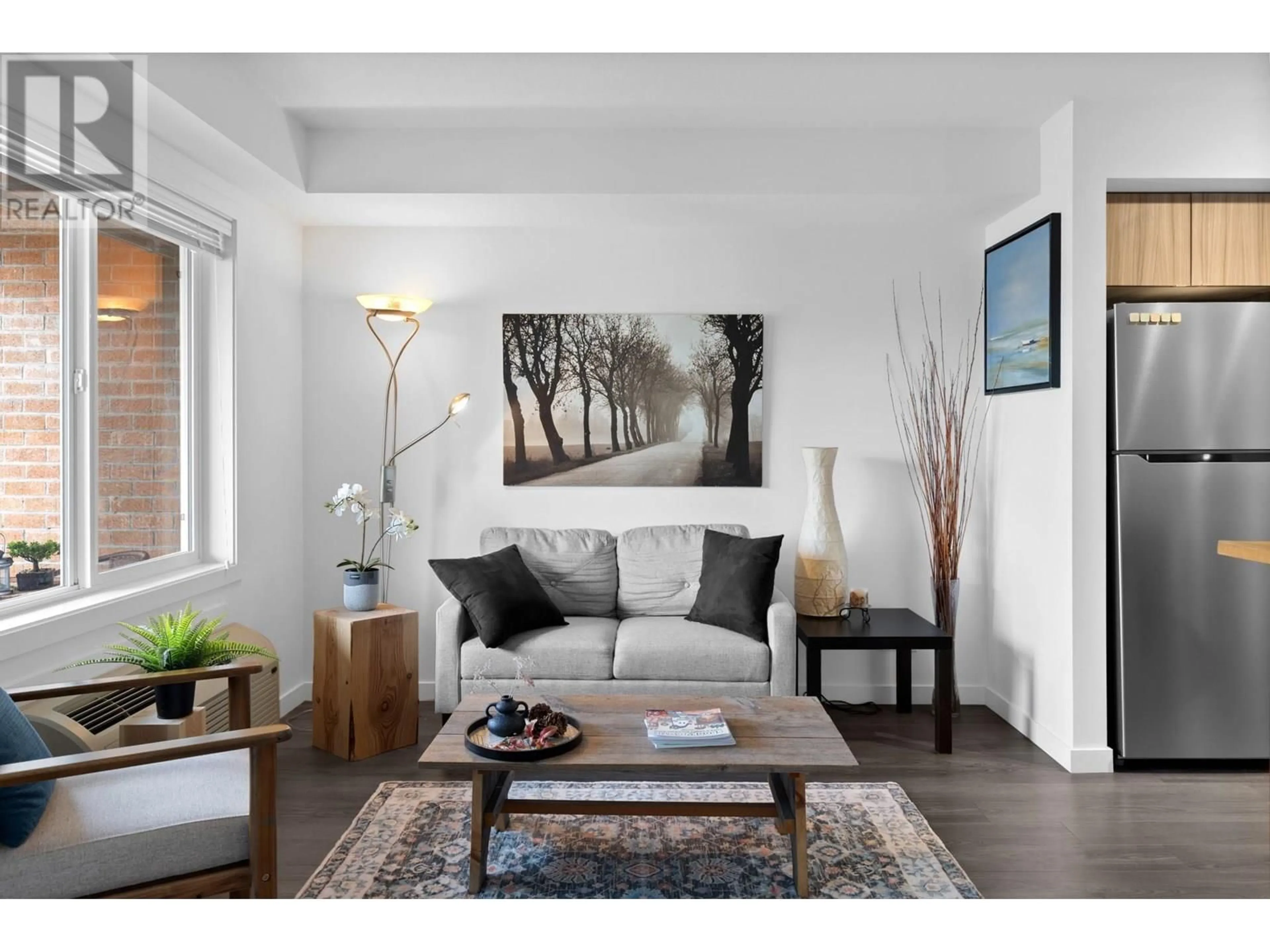 Living room with furniture, wood/laminate floor for 103 - 881 ACADEMY WAY, Kelowna British Columbia V1V0A2