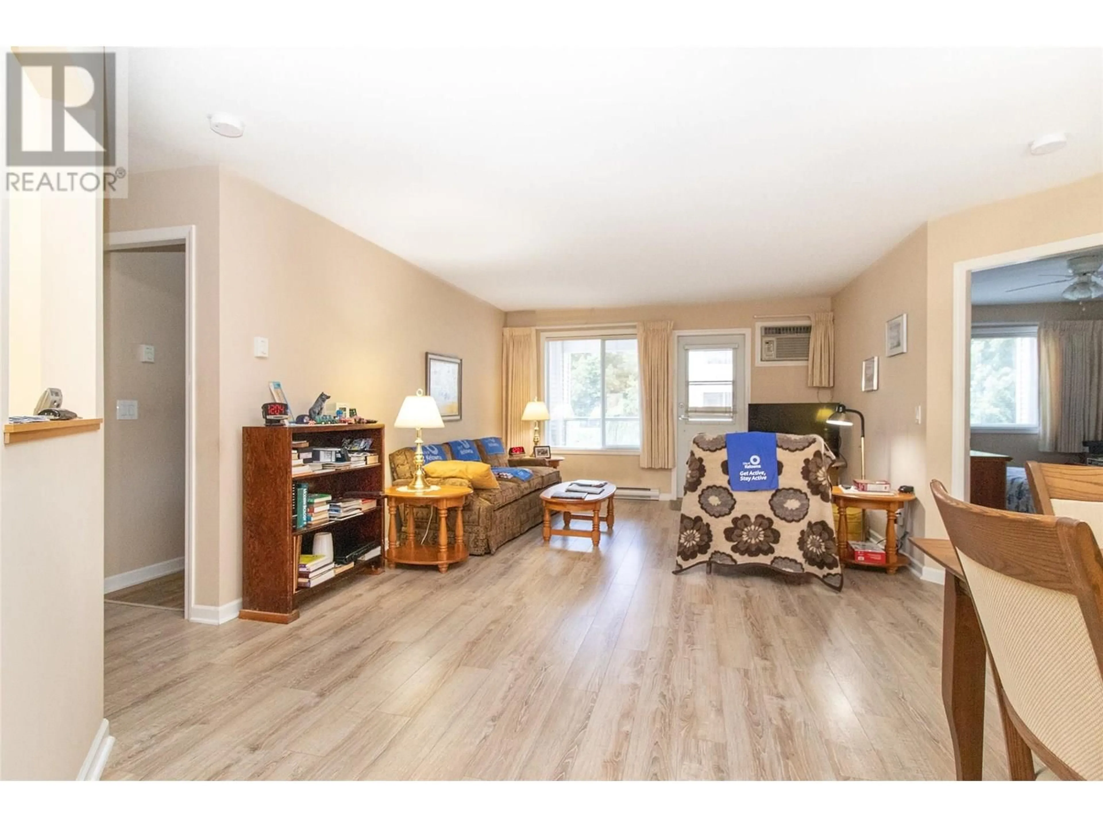 Living room with furniture, wood/laminate floor for 107 - 980 GLENWOOD AVENUE, Kelowna British Columbia V1Y9P2