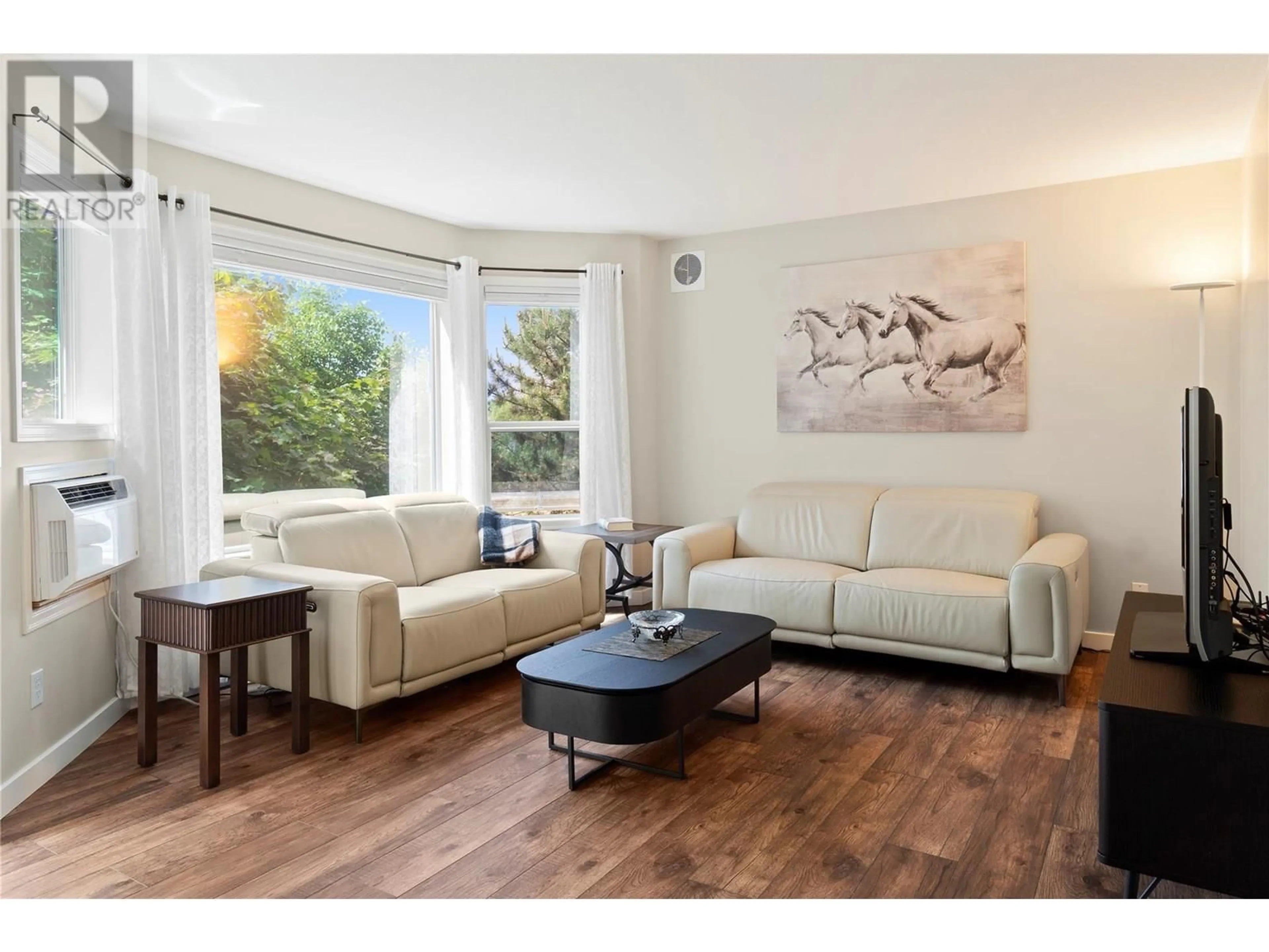 Living room with furniture, wood/laminate floor for 202 - 3283 CASORSO ROAD, Kelowna British Columbia V1W3L6