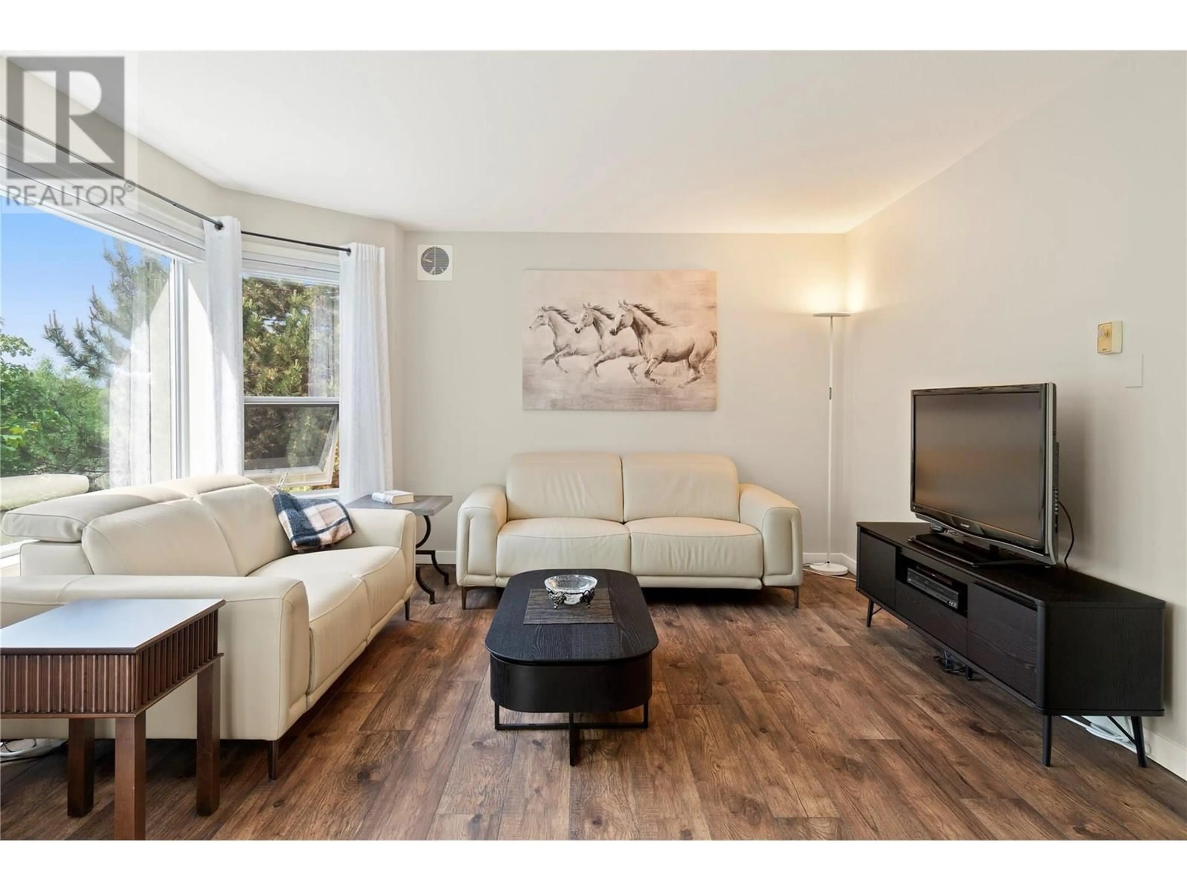 Living room with furniture, wood/laminate floor for 202 - 3283 CASORSO ROAD, Kelowna British Columbia V1W3L6