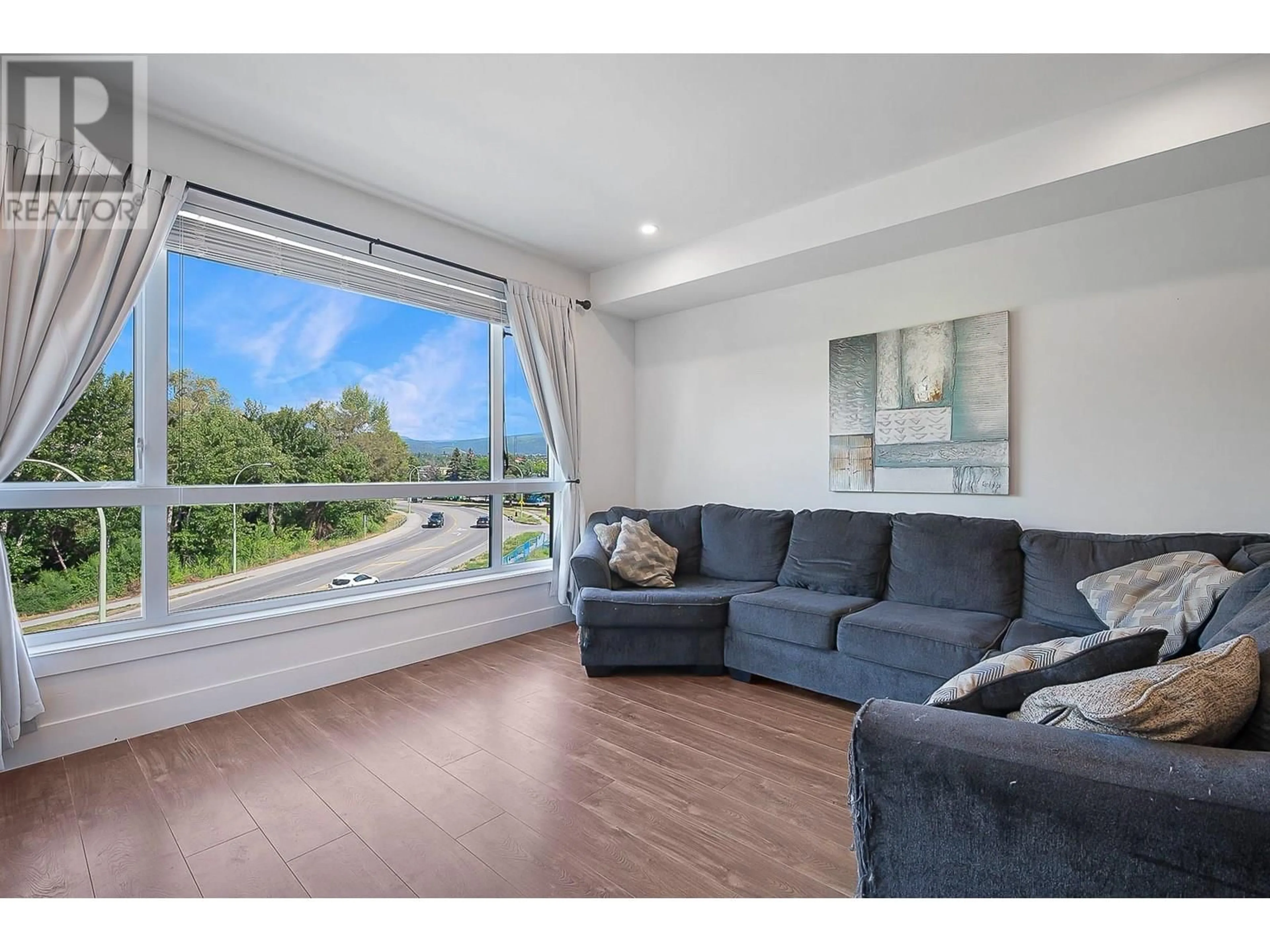 Living room with furniture, wood/laminate floor for 302 - 1925 ENTERPRISE WAY, Kelowna British Columbia V1Y0J8