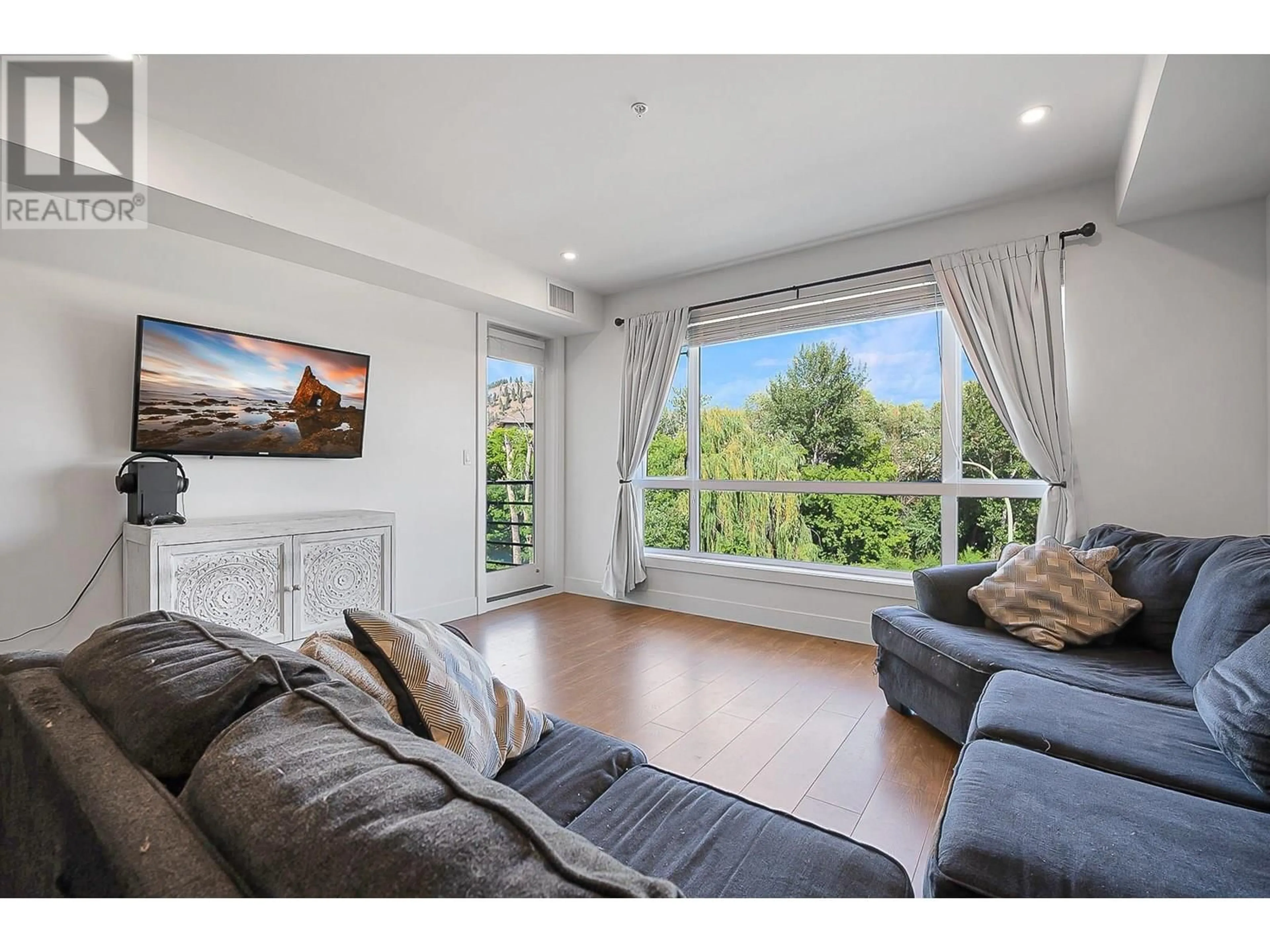 Living room with furniture, wood/laminate floor for 302 - 1925 ENTERPRISE WAY, Kelowna British Columbia V1Y0J8