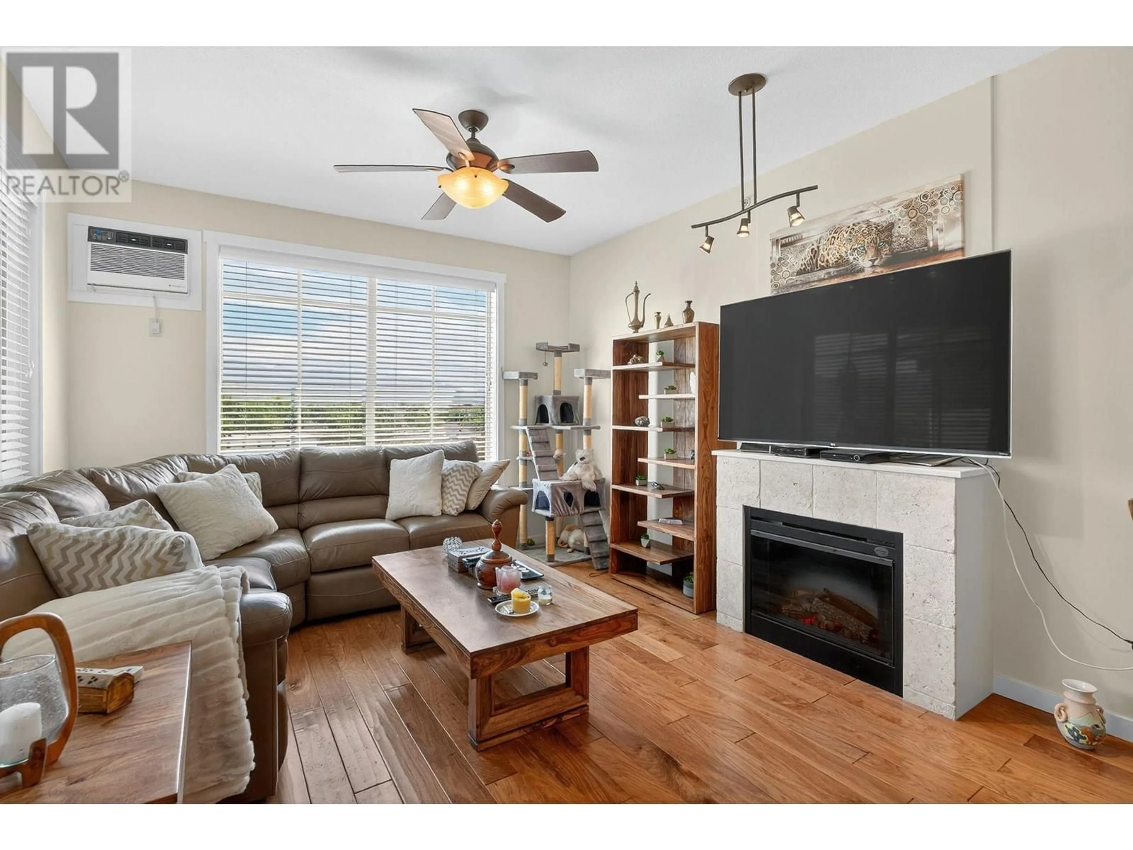 Living room with furniture, wood/laminate floor for 407 - 3739 CASORSO ROAD, Kelowna British Columbia V1W5E8