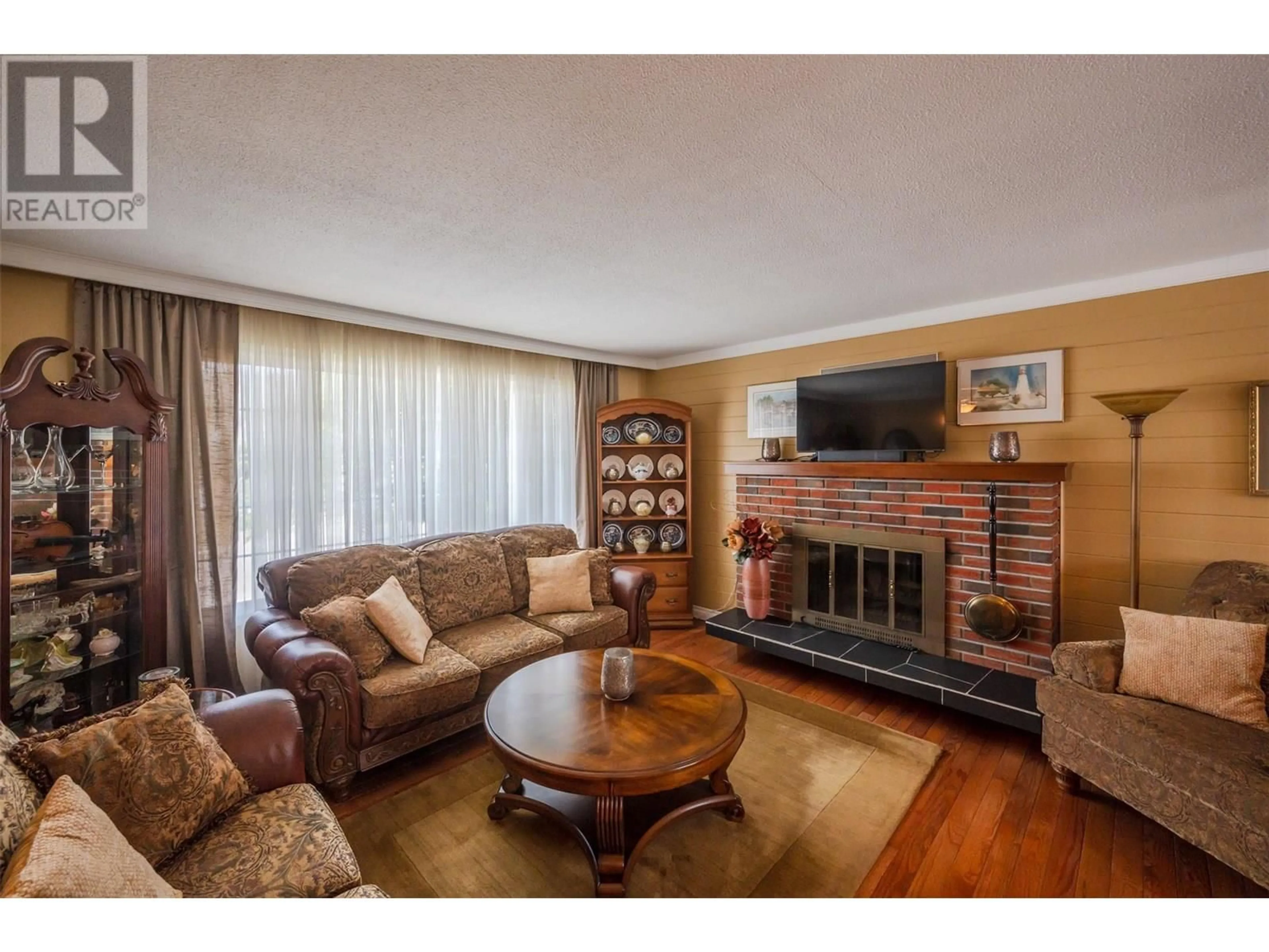 Living room with furniture, wood/laminate floor for 1598 CARMI AVENUE, Penticton British Columbia V2A6M8