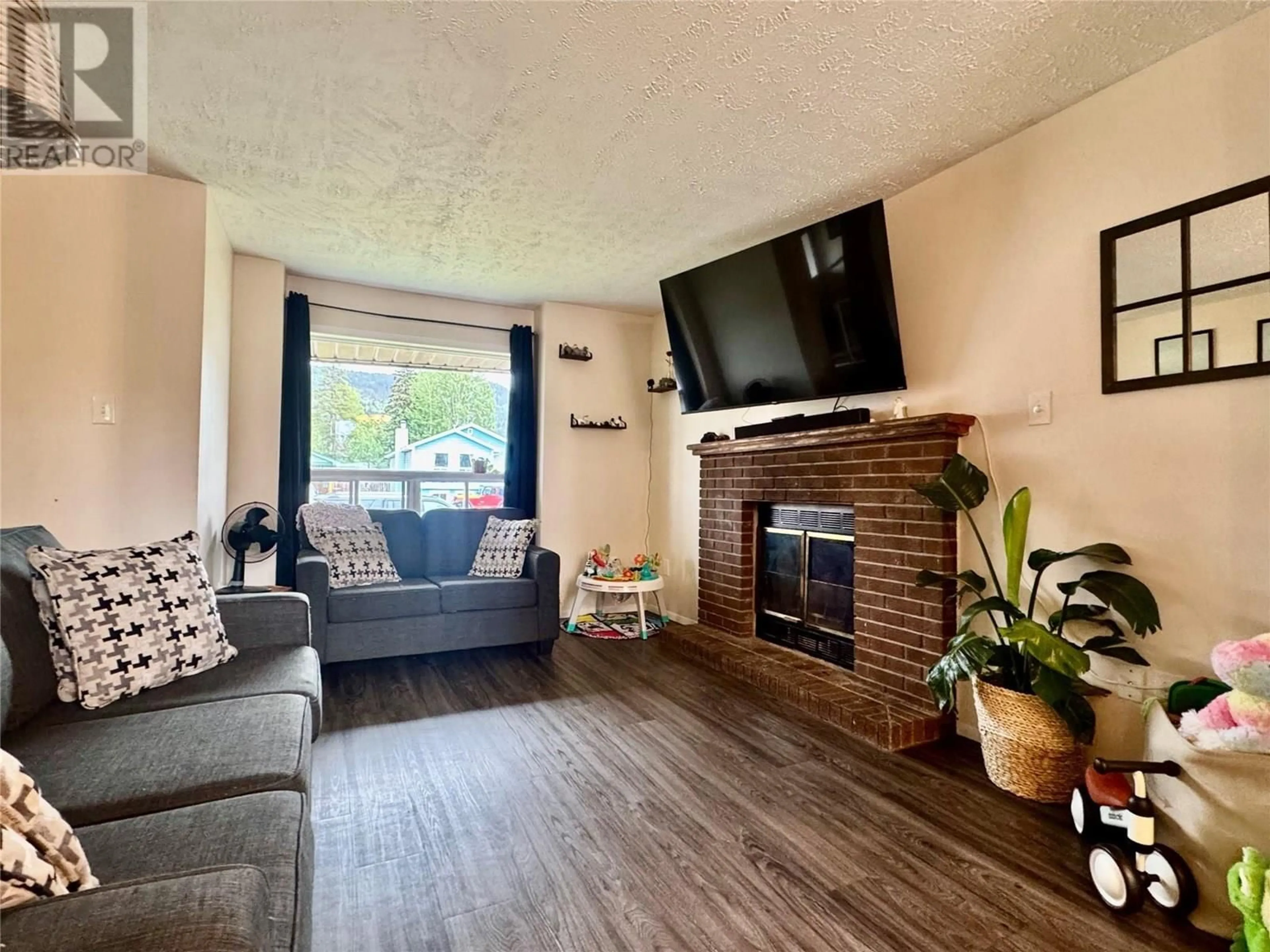 Living room with furniture, wood/laminate floor for 128 FELLERS AVENUE, Tumbler Ridge British Columbia V0C2W0
