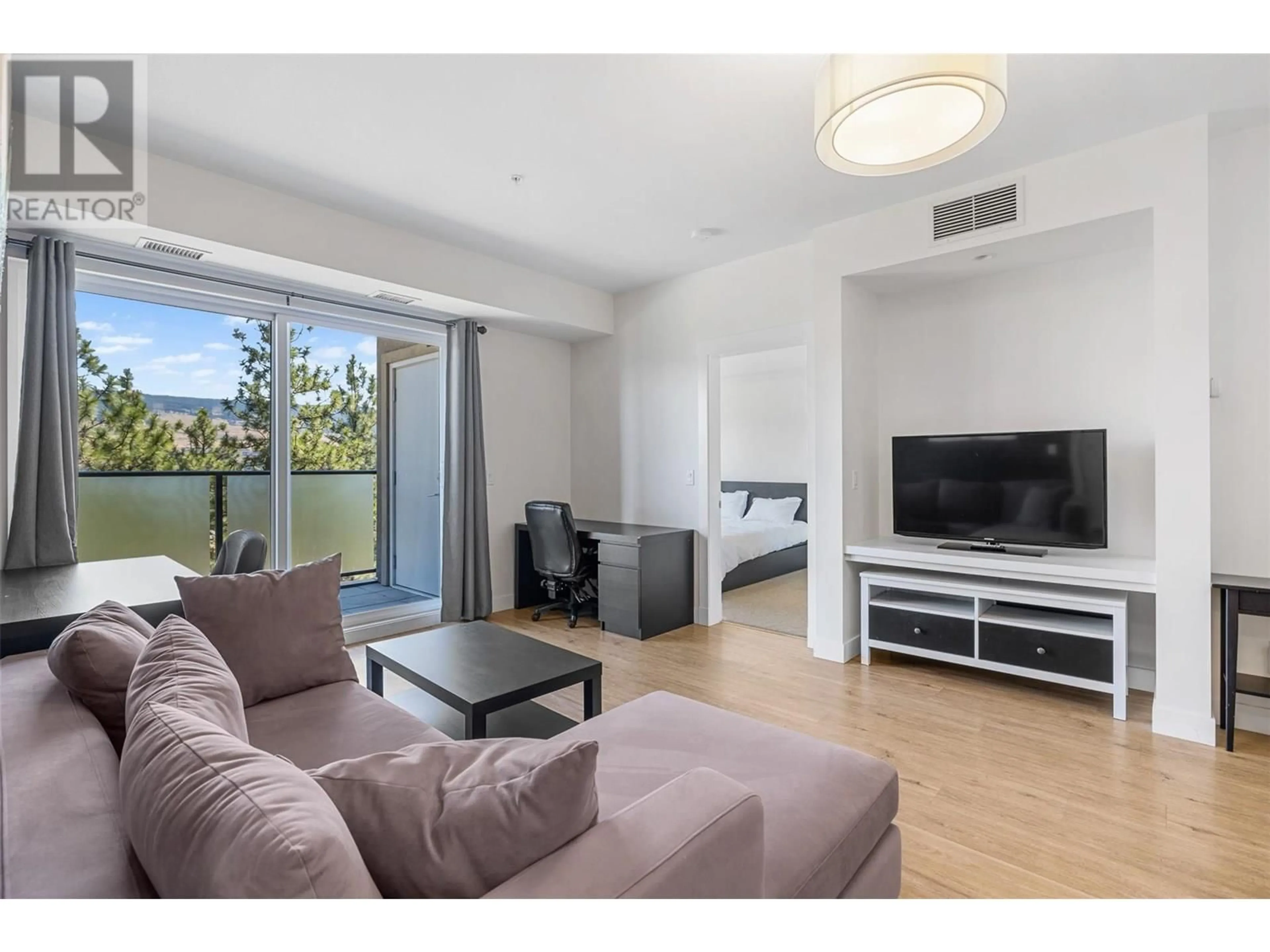 Living room with furniture, wood/laminate floor for 104 - 985 ACADEMY WAY, Kelowna British Columbia V1V3C8