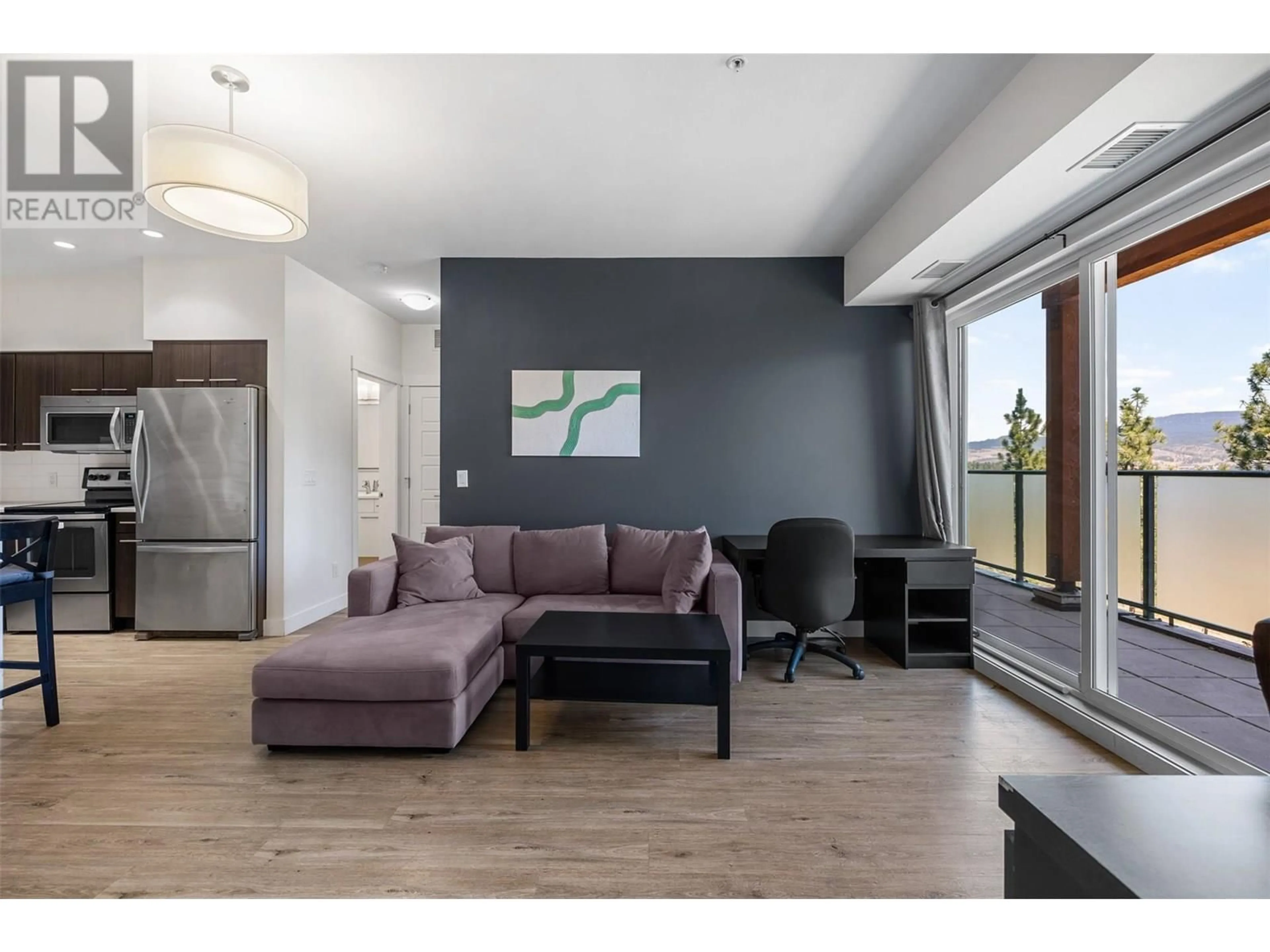 Living room with furniture, wood/laminate floor for 104 - 985 ACADEMY WAY, Kelowna British Columbia V1V3C8