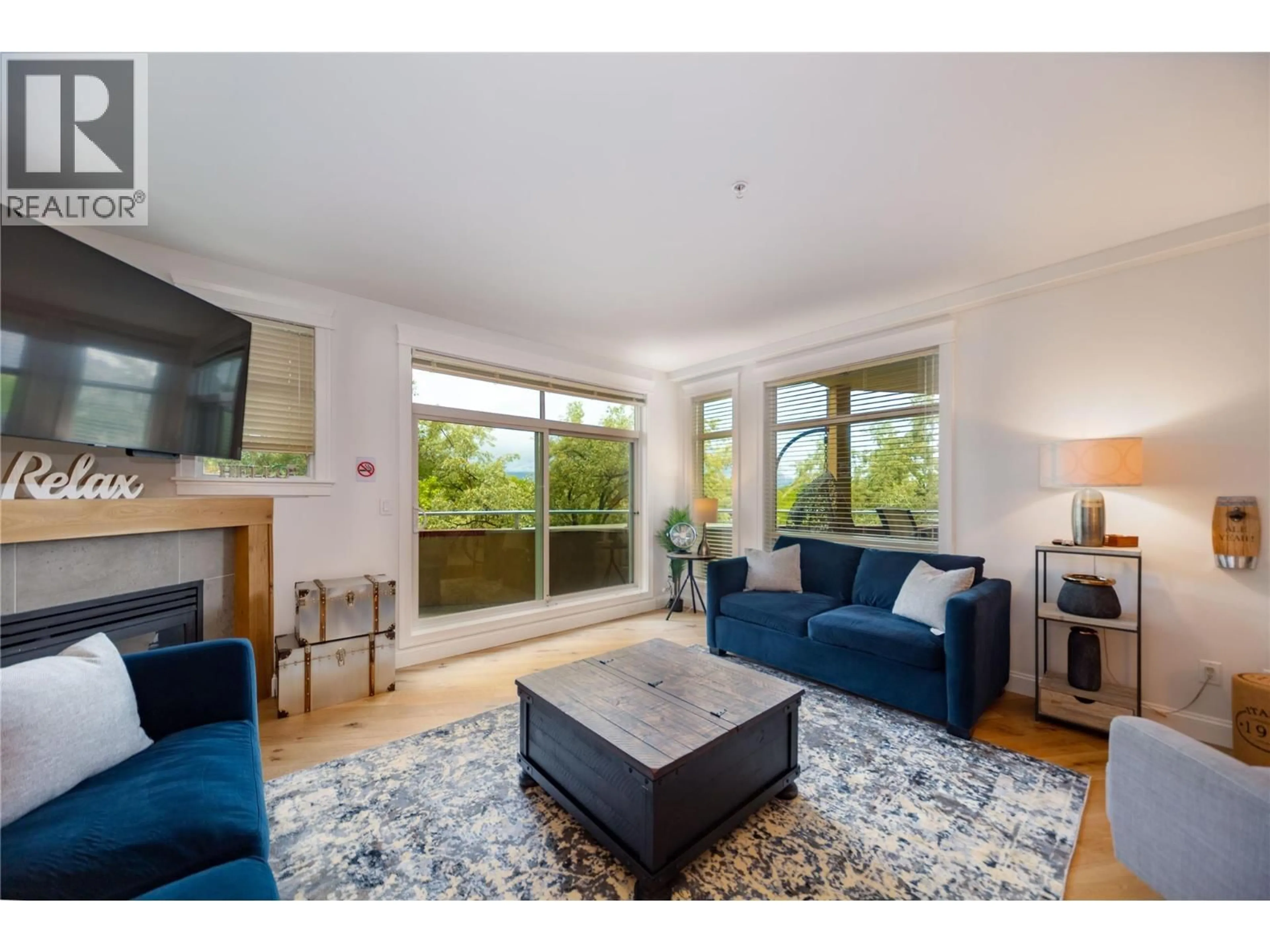Living room with furniture, wood/laminate floor for 310 - 1088 SUNSET DRIVE, Kelowna British Columbia V1Y9W1
