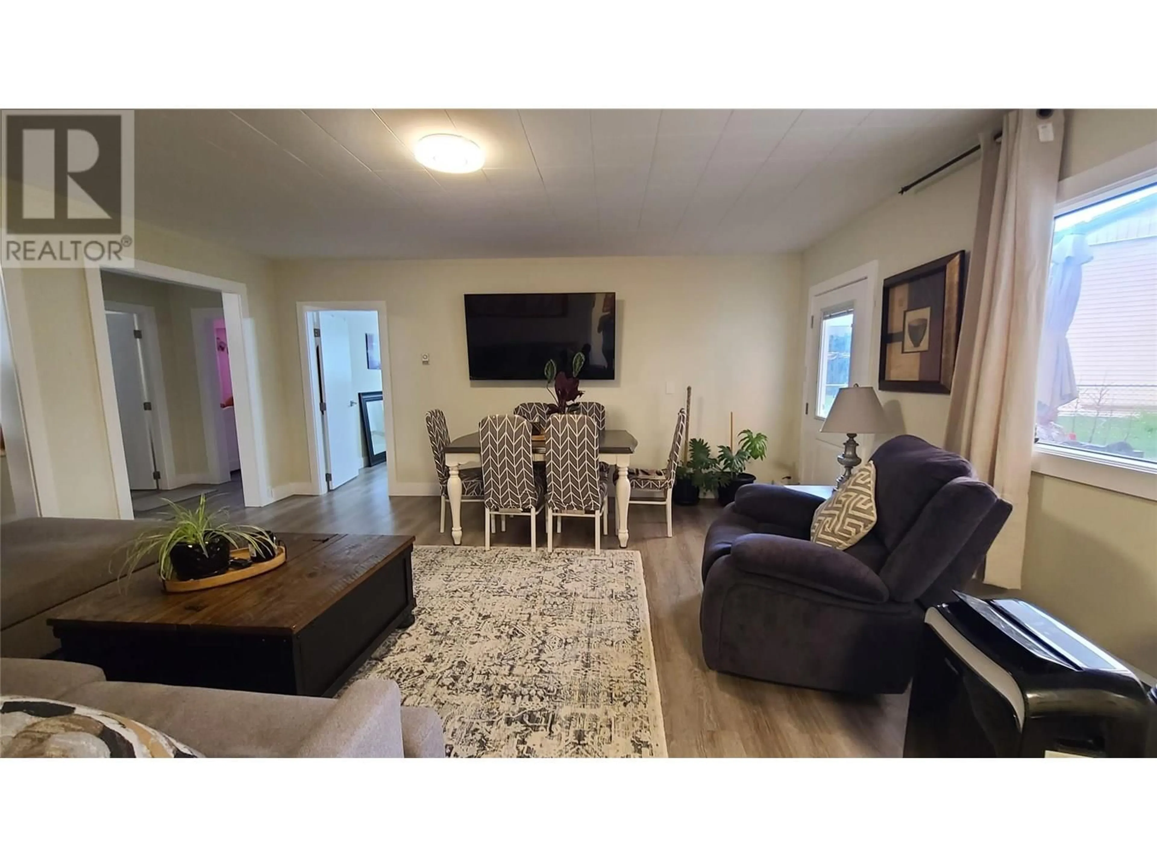 Living room with furniture, wood/laminate floor for 6488 WOLFCUB PLACE, Oliver British Columbia V0H1T3