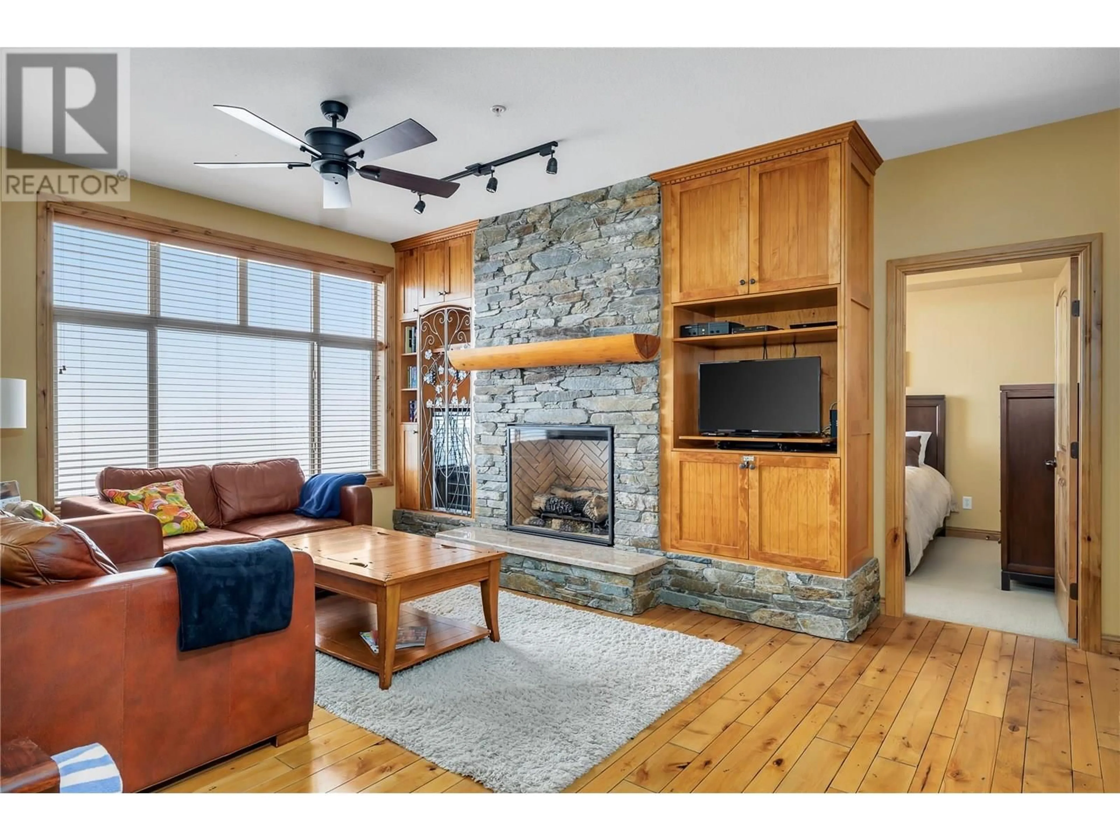 Living room with furniture, wood/laminate floor for 311 - 7700 PORCUPINE ROAD, Big White British Columbia V1P1P3