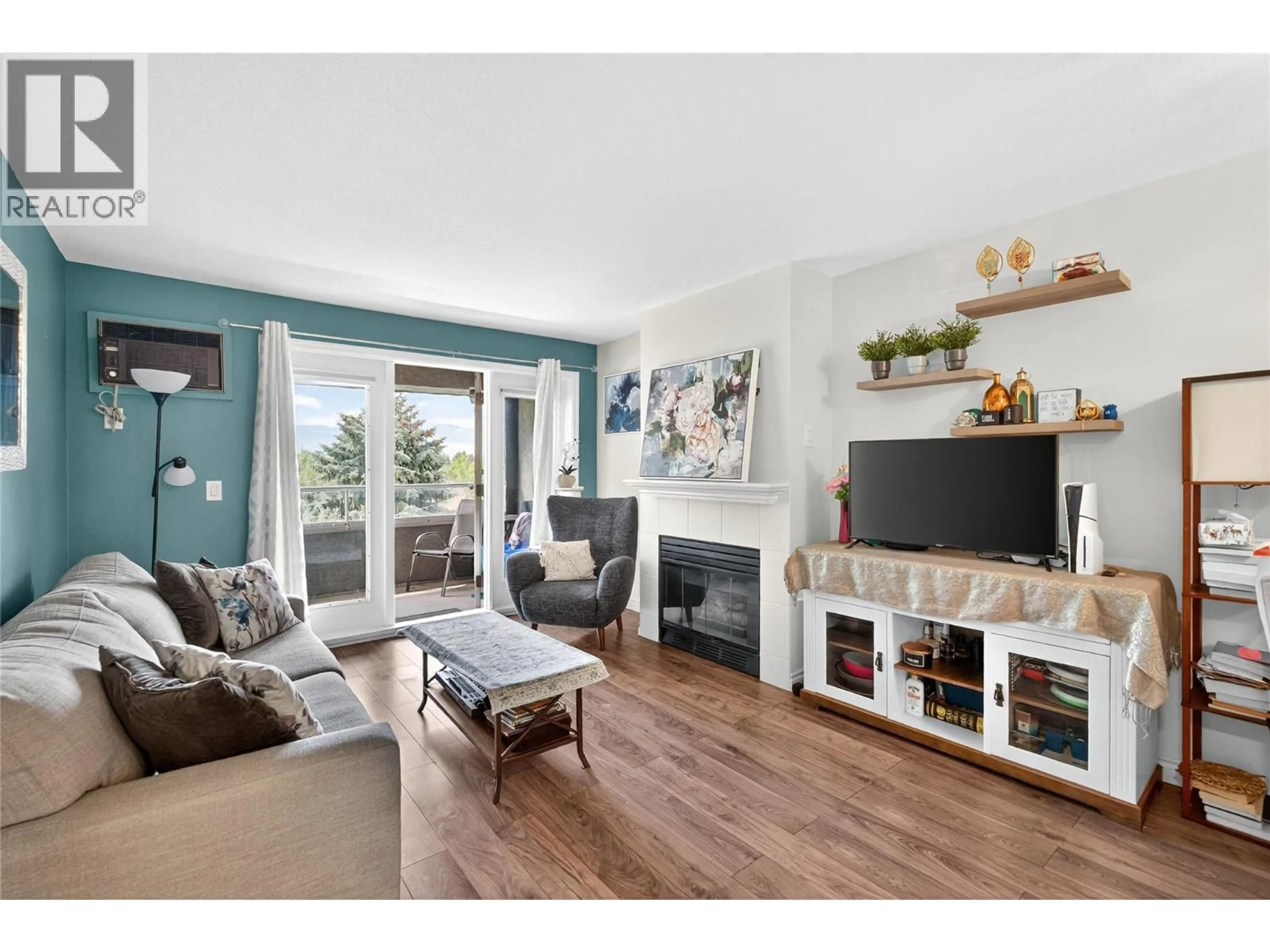 Living room with furniture, wood/laminate floor for 412 - 3175 DE MONTREUIL COURT, Kelowna British Columbia V1W3W2