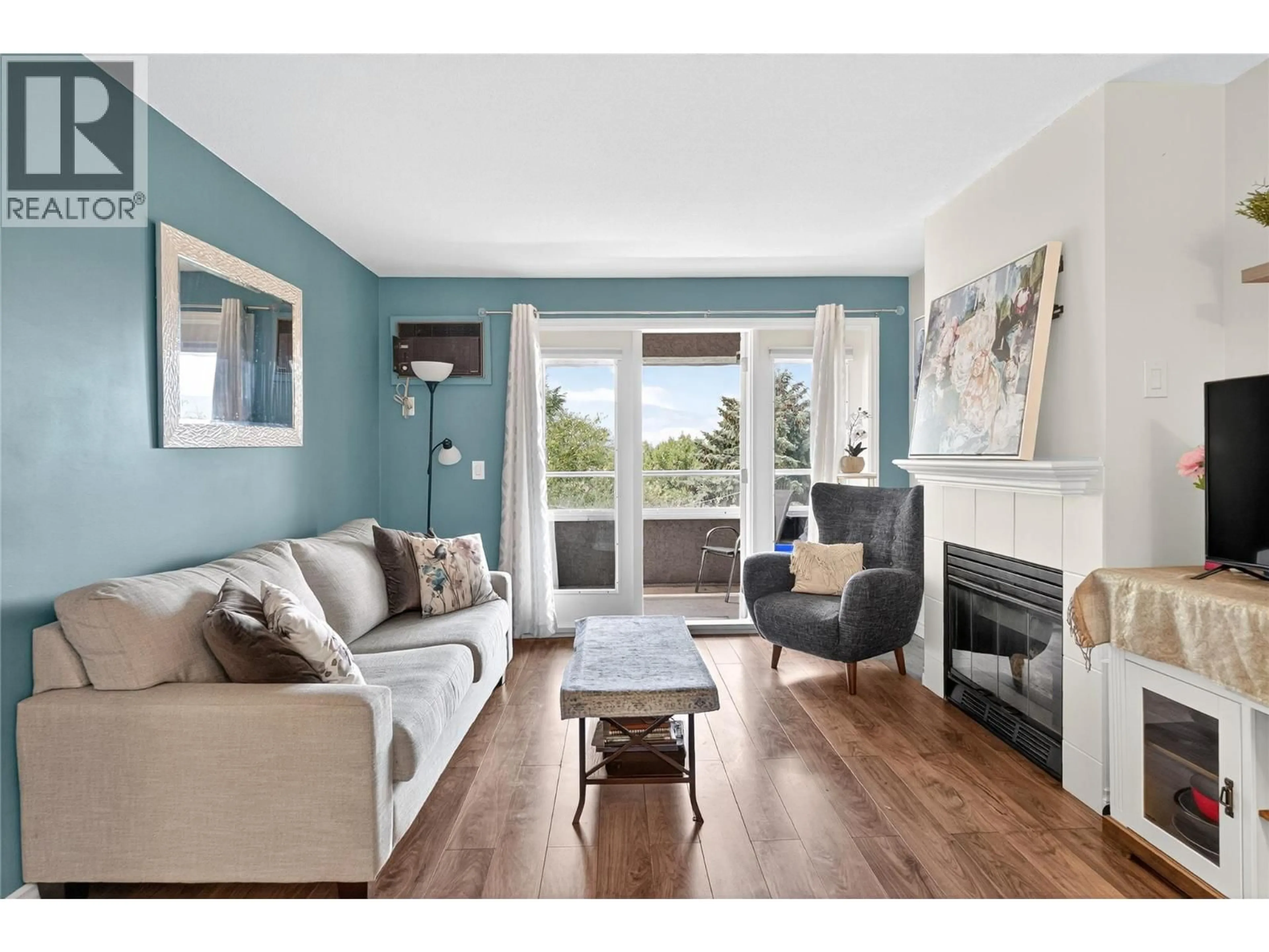 Living room with furniture, wood/laminate floor for 412 - 3175 DE MONTREUIL COURT, Kelowna British Columbia V1W3W2