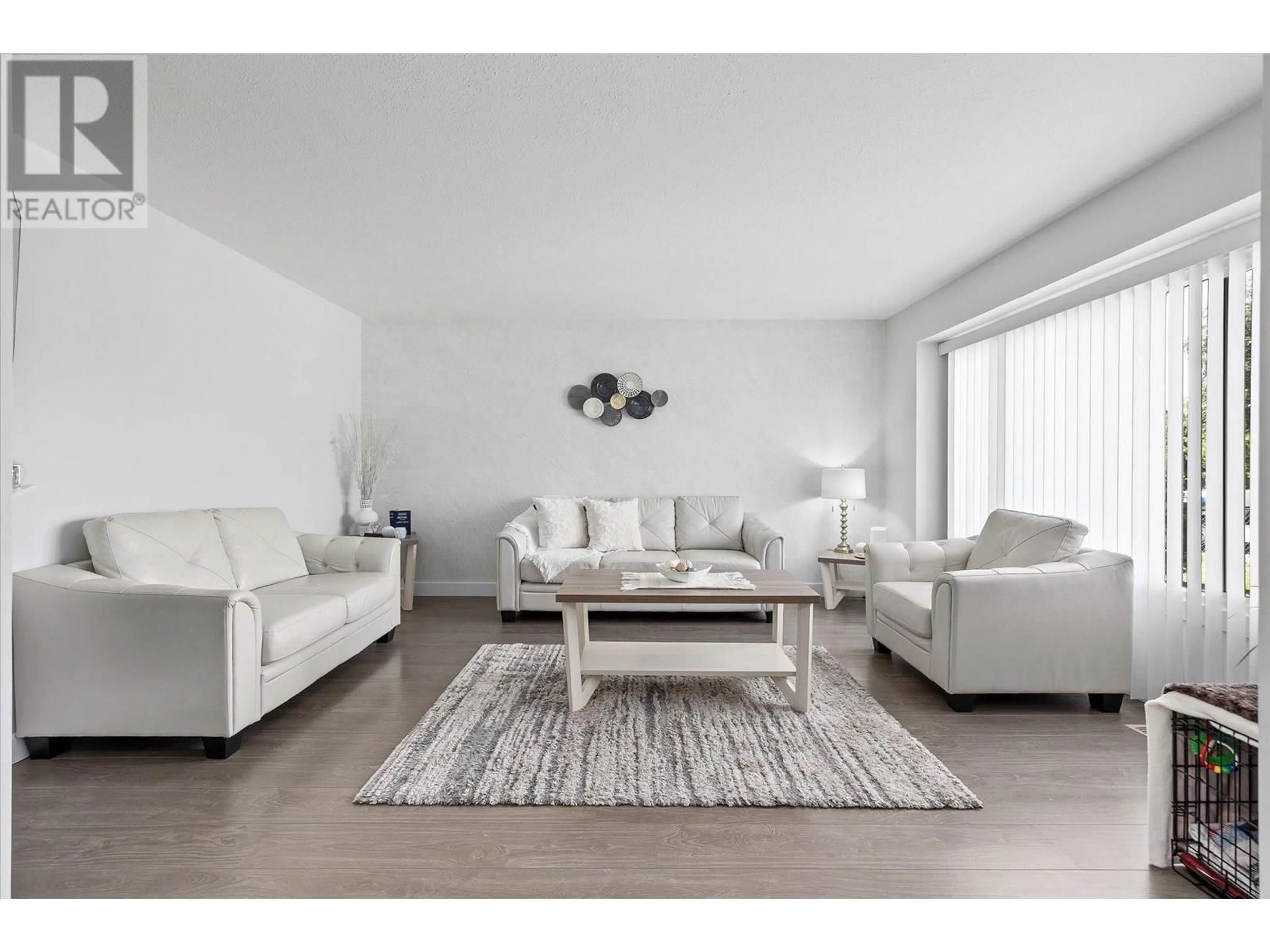 Living room with furniture, wood/laminate floor for 135 ALMOND COURT, Kelowna British Columbia V1X6H1