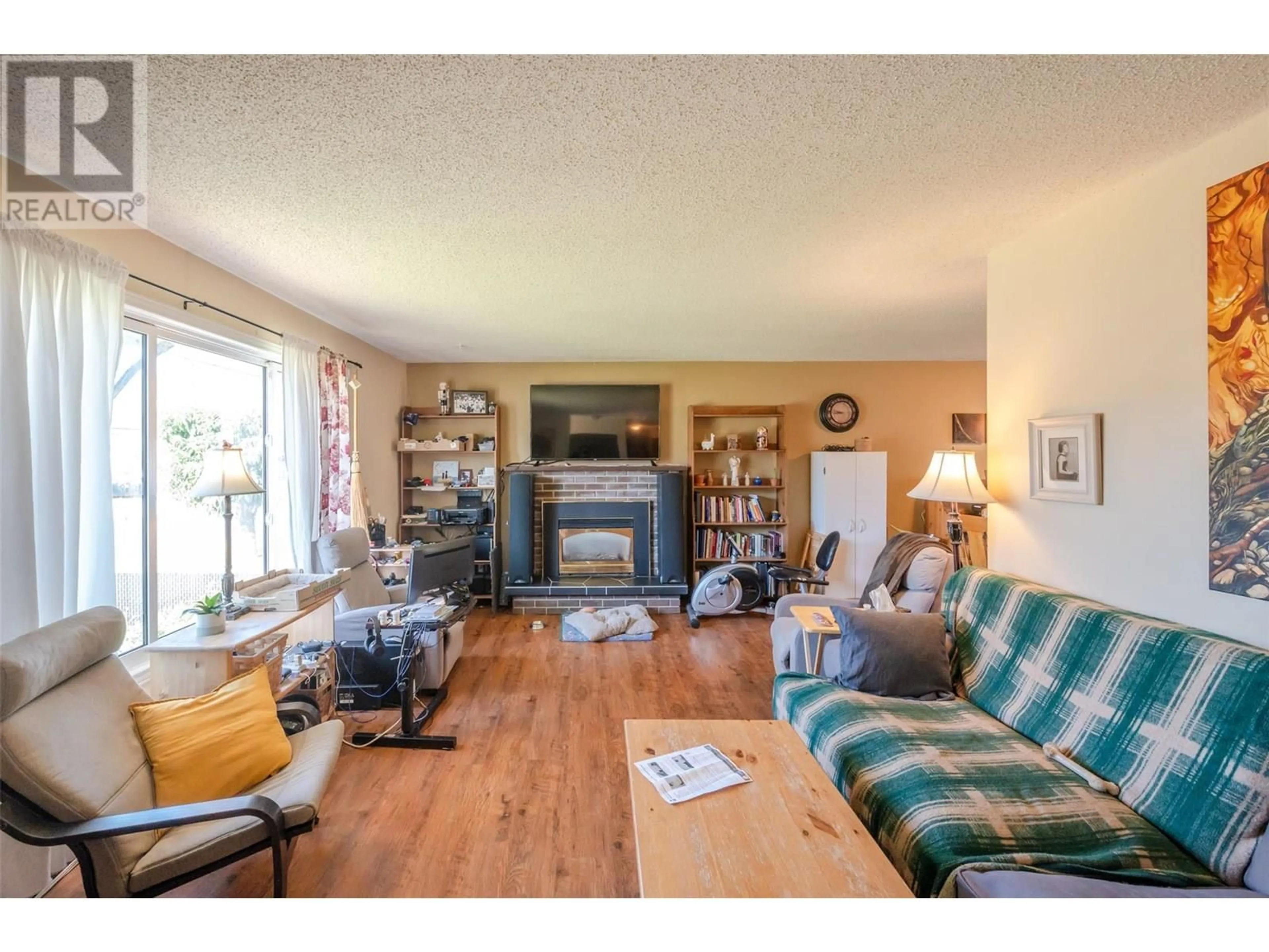 Living room with furniture, wood/laminate floor for 171 HUTH AVENUE, Penticton British Columbia V2A2Z7