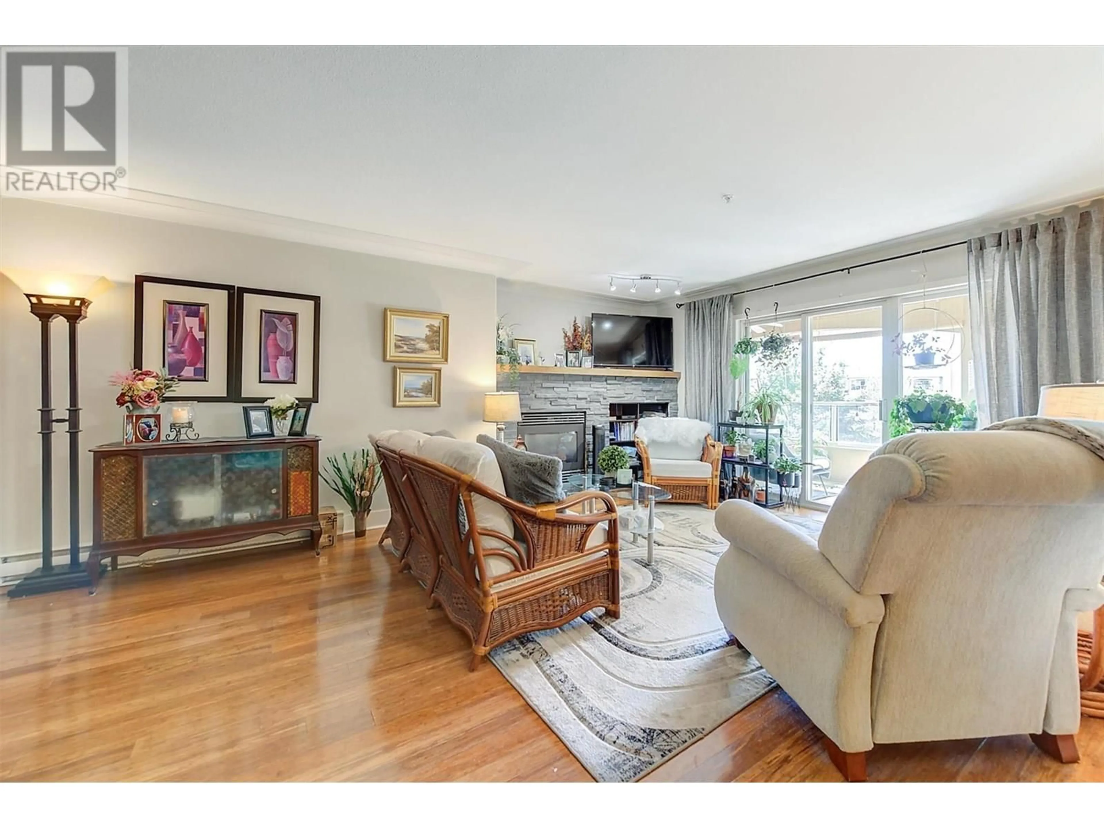 Living room with furniture, wood/laminate floor for 309 - 1964 ENTERPRISE WAY, Kelowna British Columbia V1Y9S7