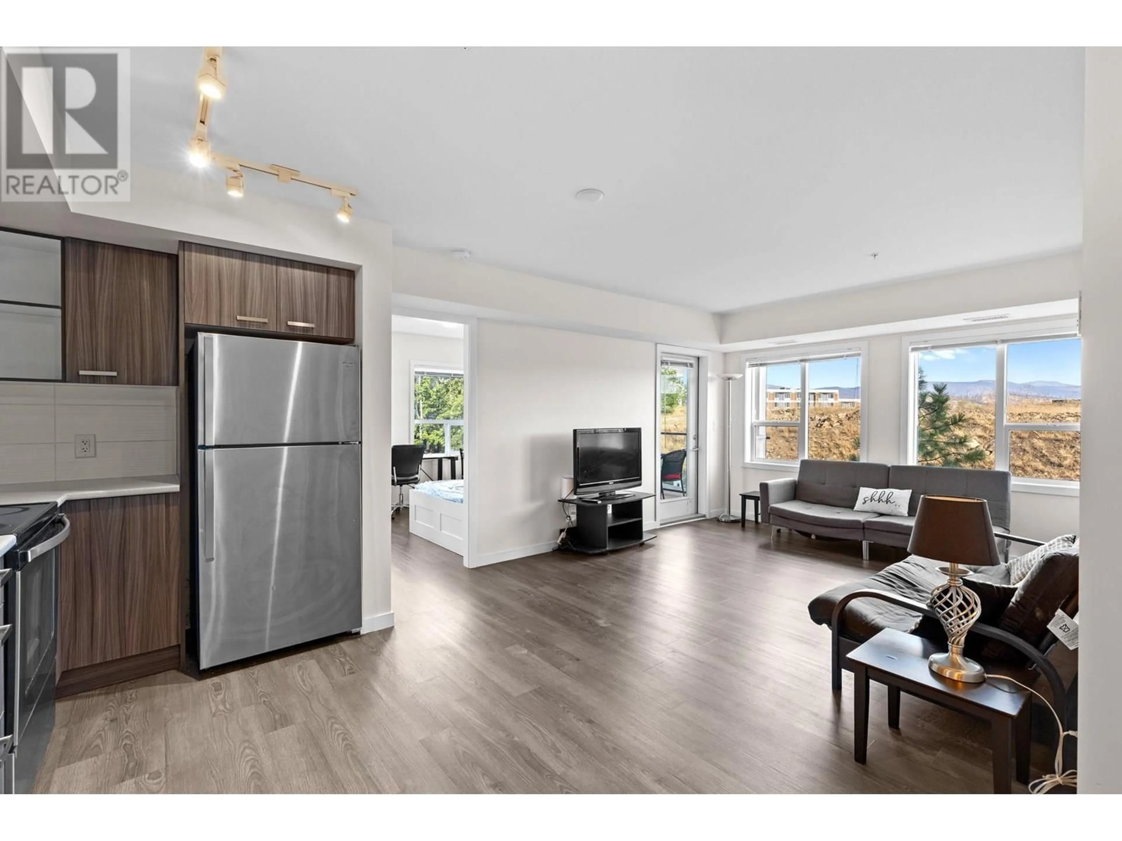 Open concept kitchen, wood/laminate floor for 107 - 775 ACADEMY WAY, Kelowna British Columbia V4C2C6