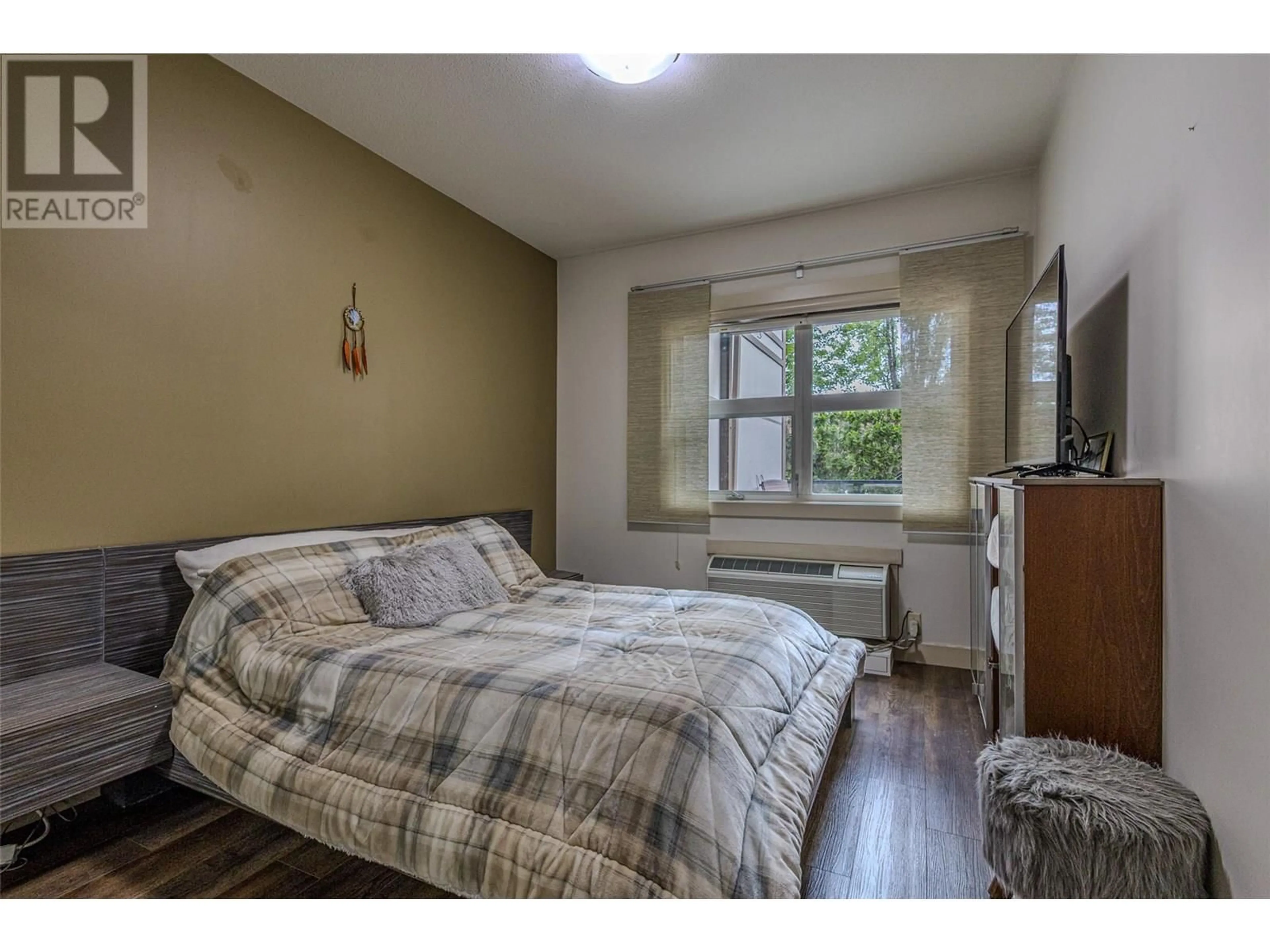 Bedroom with bed, wood/laminate floor for 106 - 700 MARTIN AVENUE, Kelowna British Columbia V1Y6V3