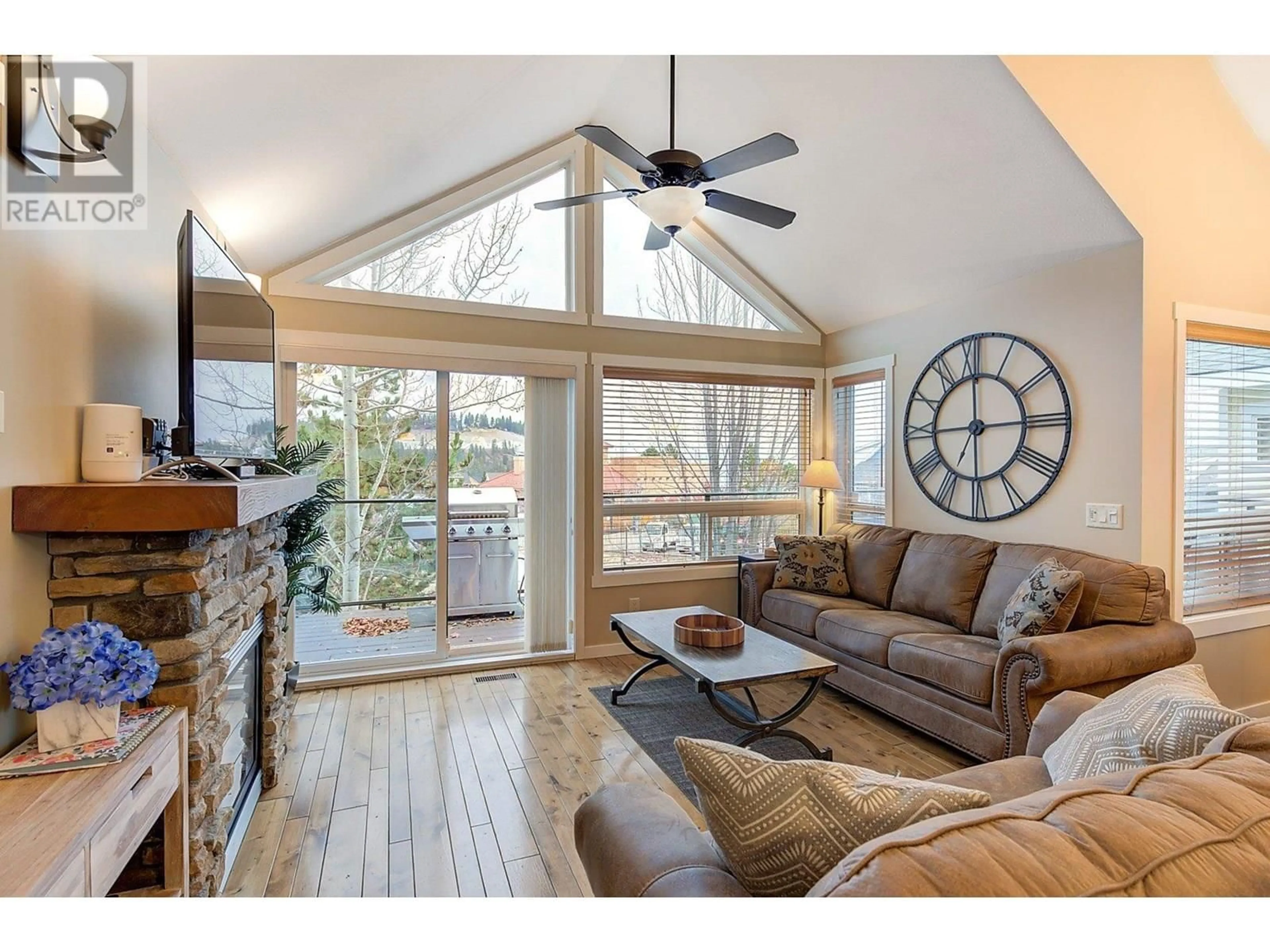 Living room with furniture, wood/laminate floor for 6823 MADRID WAY, Kelowna British Columbia V1Z3R8