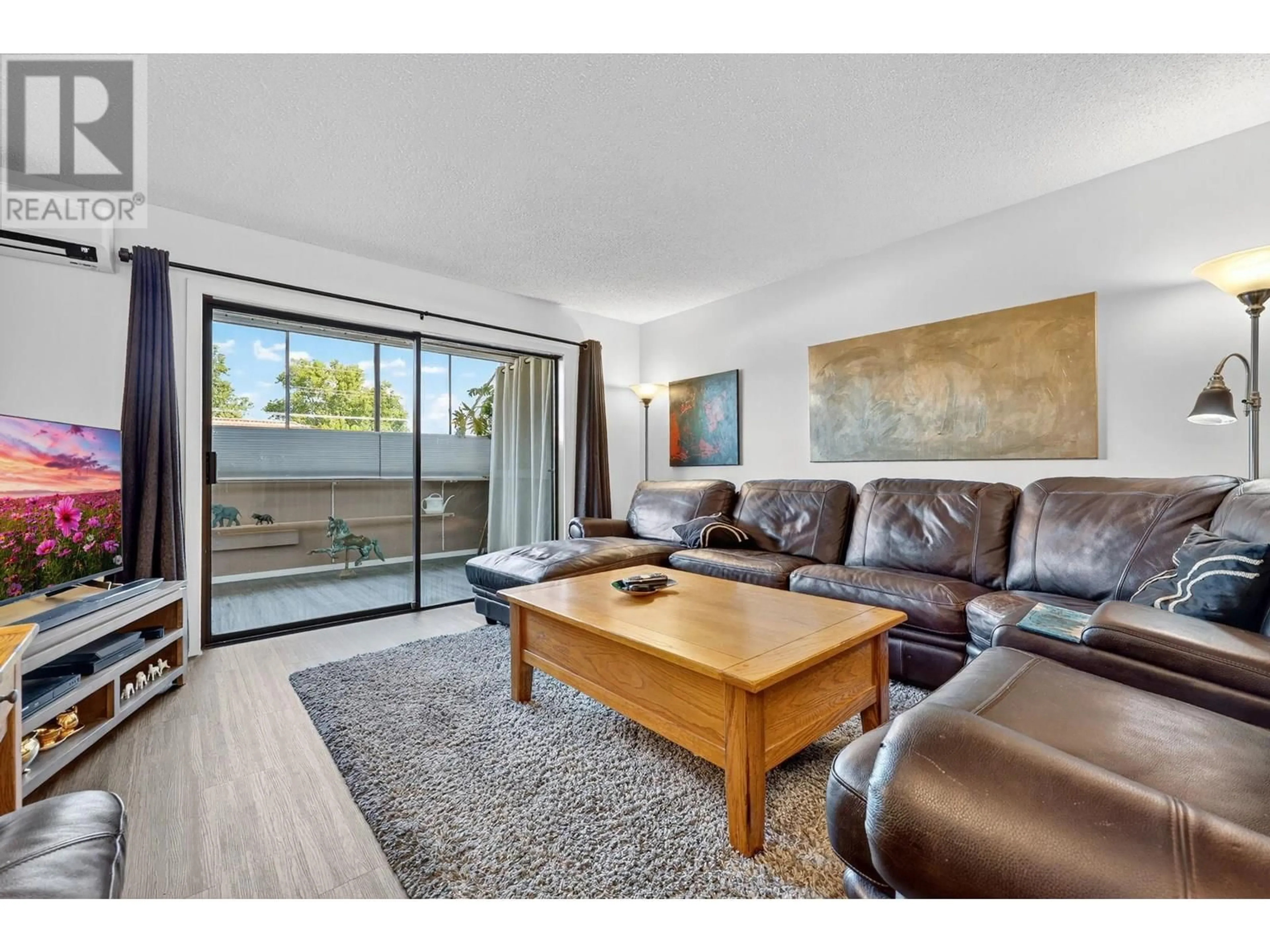 Living room with furniture, wood/laminate floor for 116 - 2085 GORDON DRIVE, Kelowna British Columbia V1Y8S1