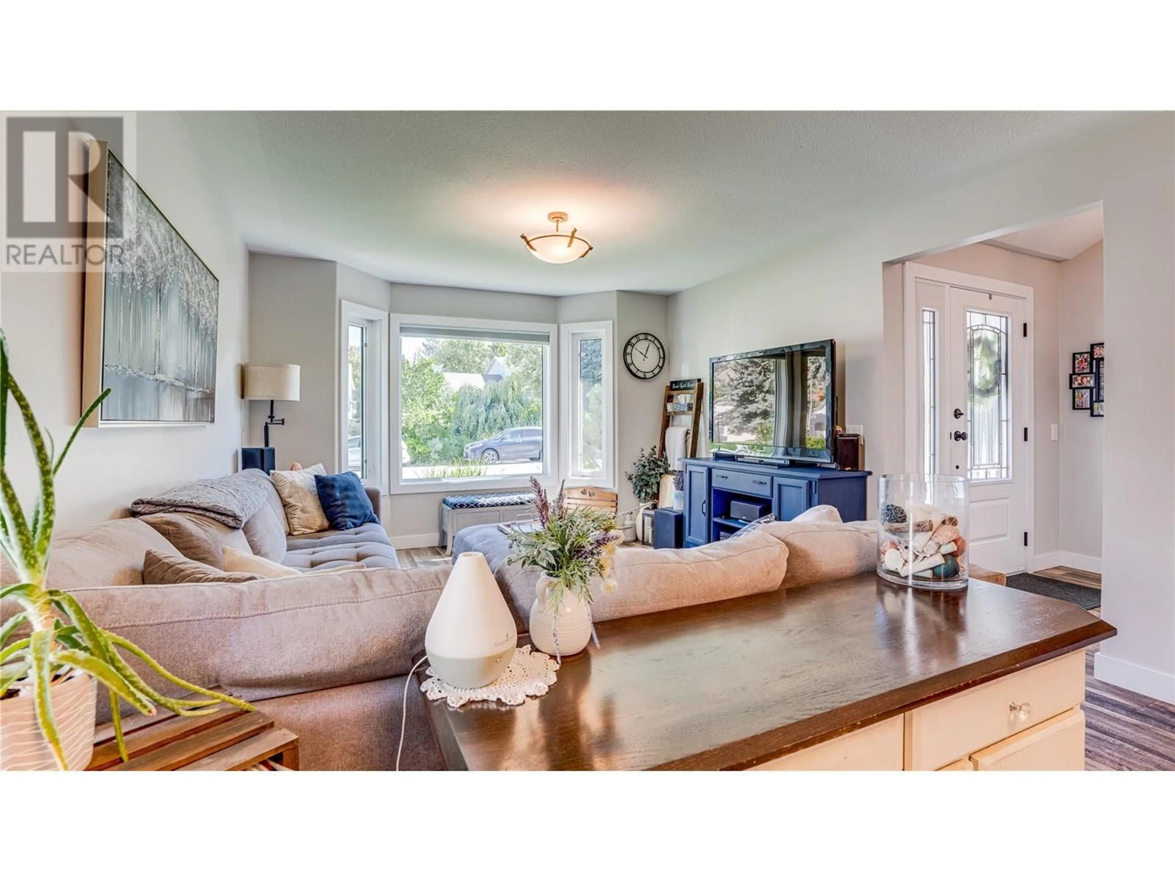 Living room with furniture, wood/laminate floor for 6440 WOODLAND DRIVE, Coldstream British Columbia V1B3G7