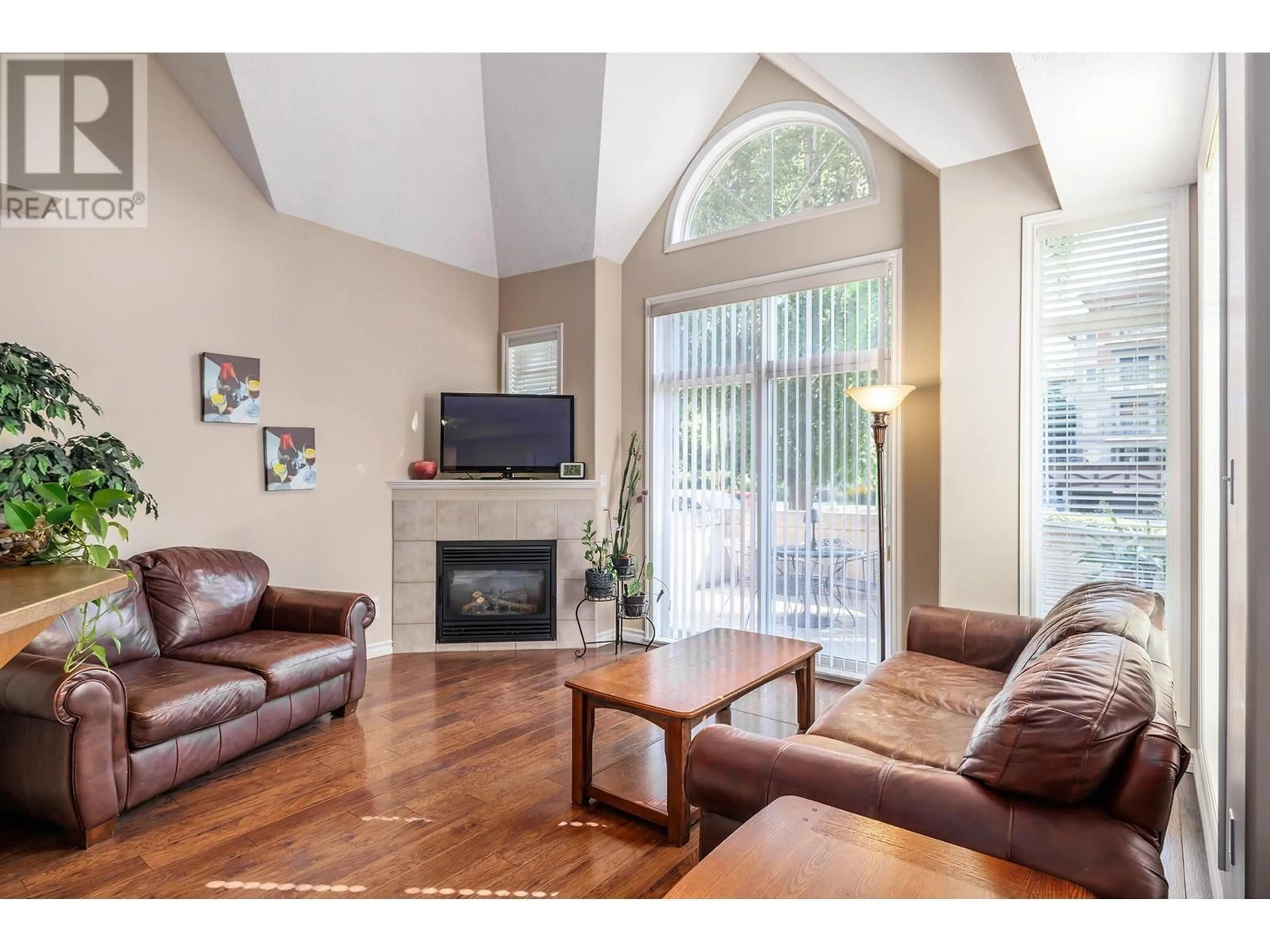 Living room with furniture, wood/laminate floor for 102 - 1128 SUNSET DRIVE, Kelowna British Columbia V1Y9W1