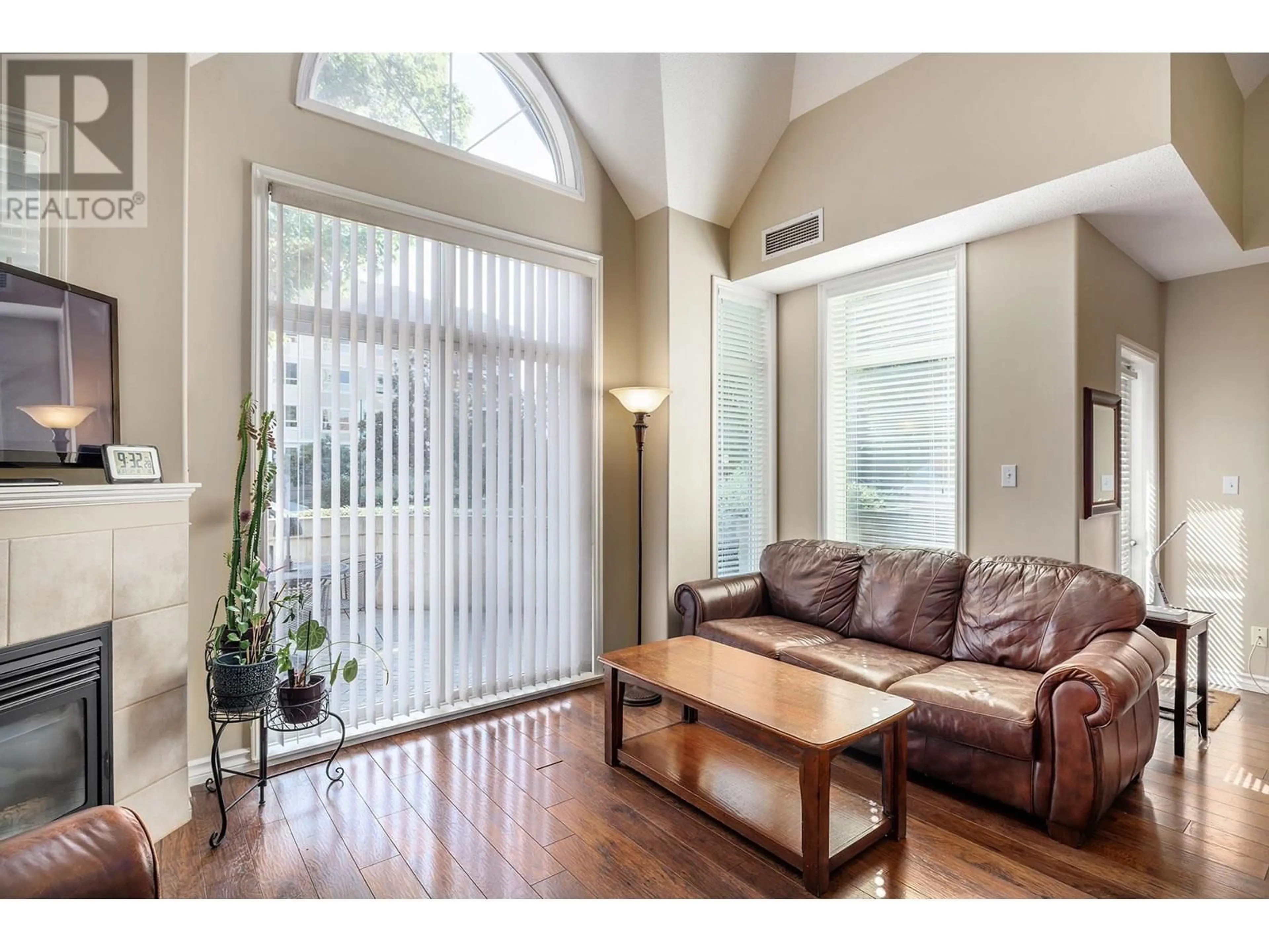 Living room with furniture, wood/laminate floor for 102 - 1128 SUNSET DRIVE, Kelowna British Columbia V1Y9W1