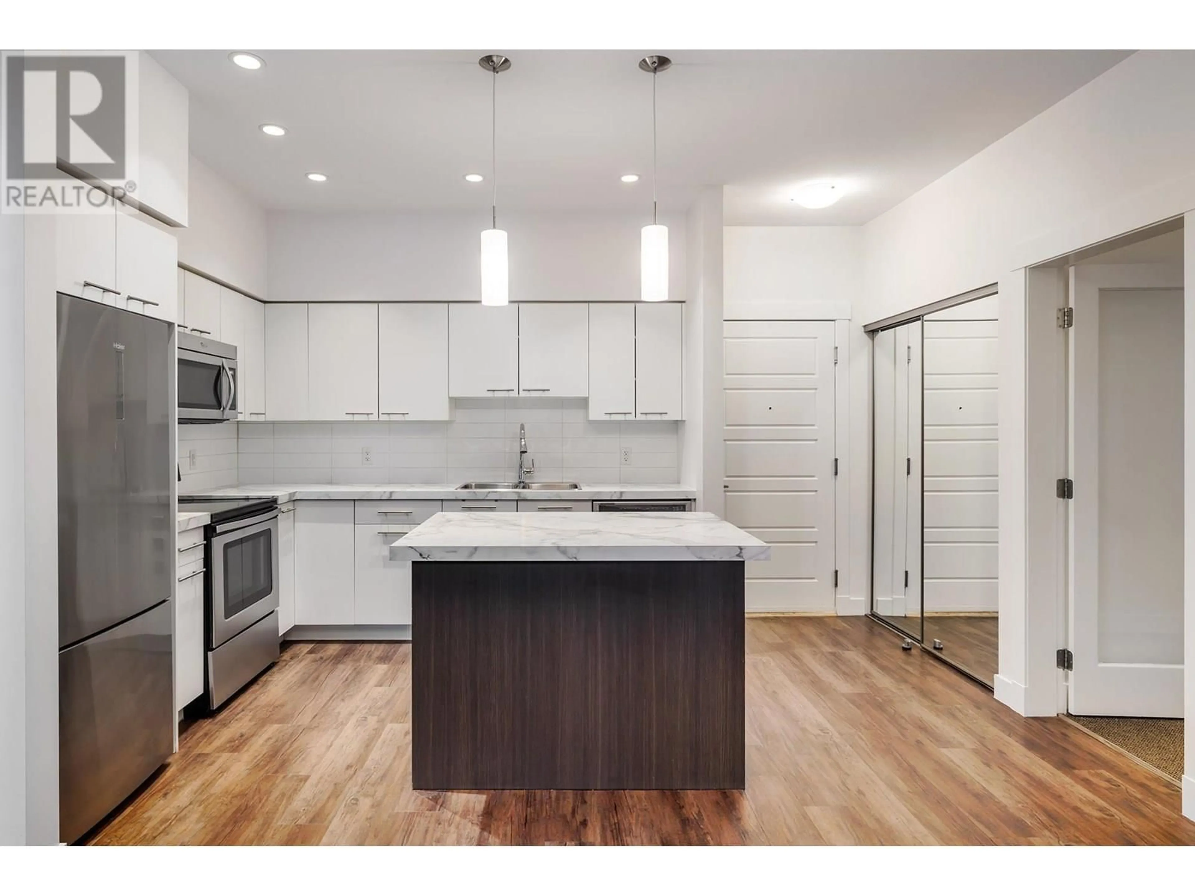 Open concept kitchen, wood/laminate floor for 214 - 975 ACADEMY WAY, Kelowna British Columbia V1V3C8