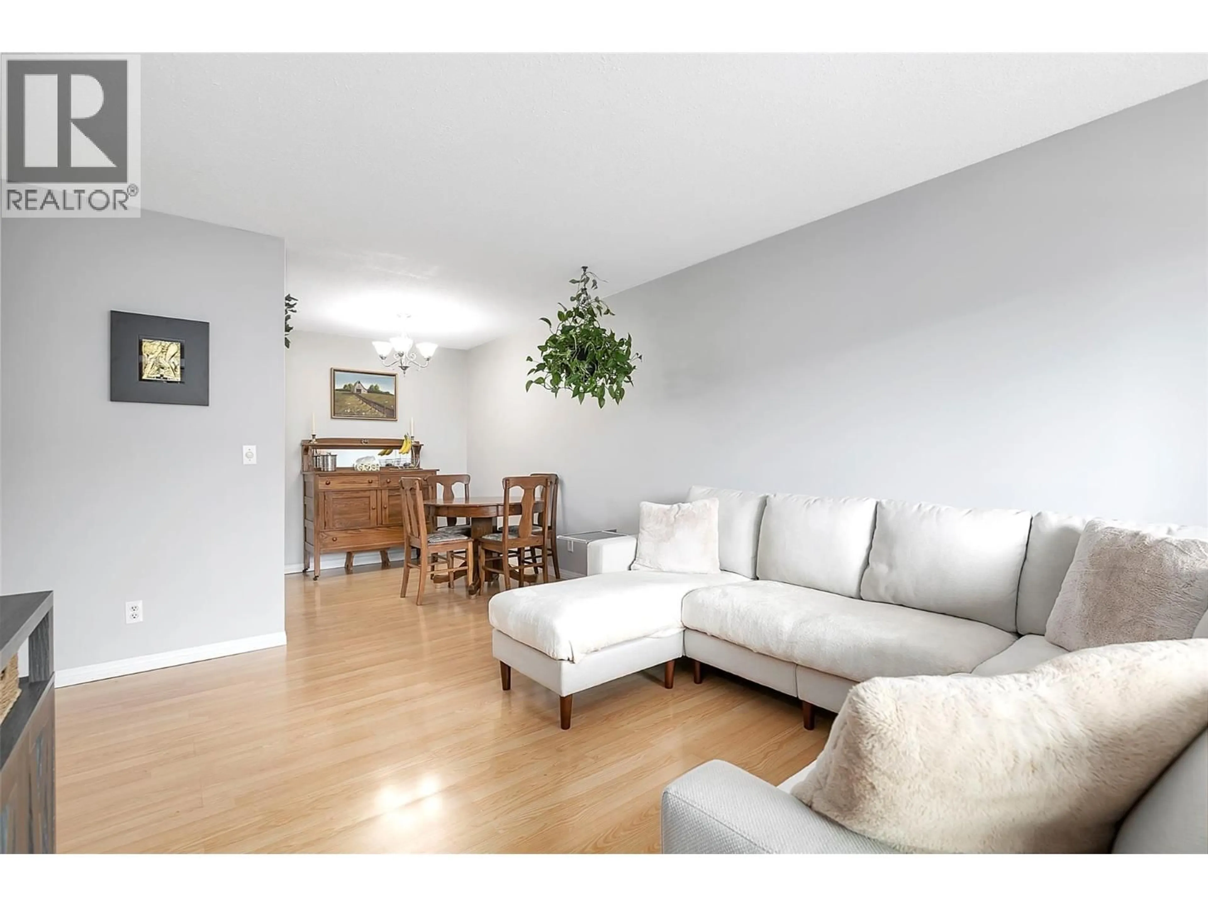 Living room with furniture, wood/laminate floor for 211 - 445 ALL STAR COURT, Kelowna British Columbia V1X5N7