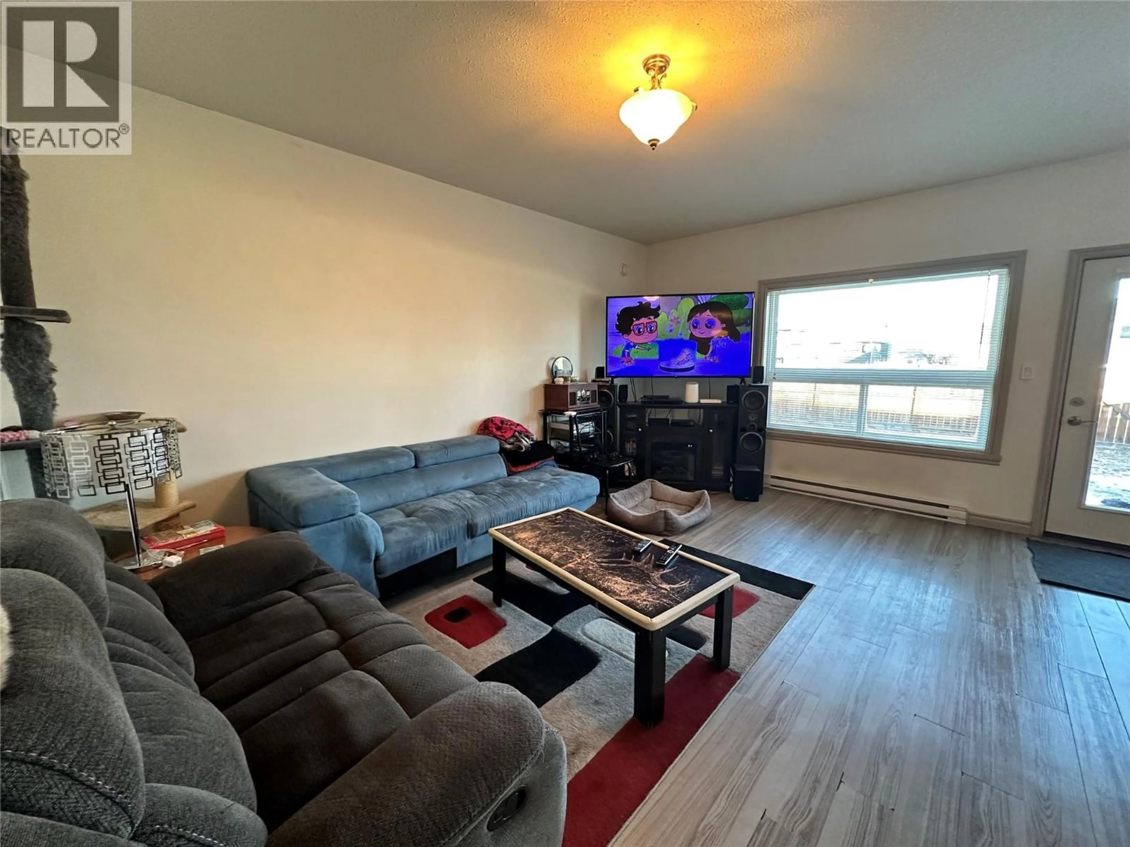 Living room with furniture, wood/laminate floor for 1544 117 AVENUE, Dawson Creek British Columbia V1G0E7