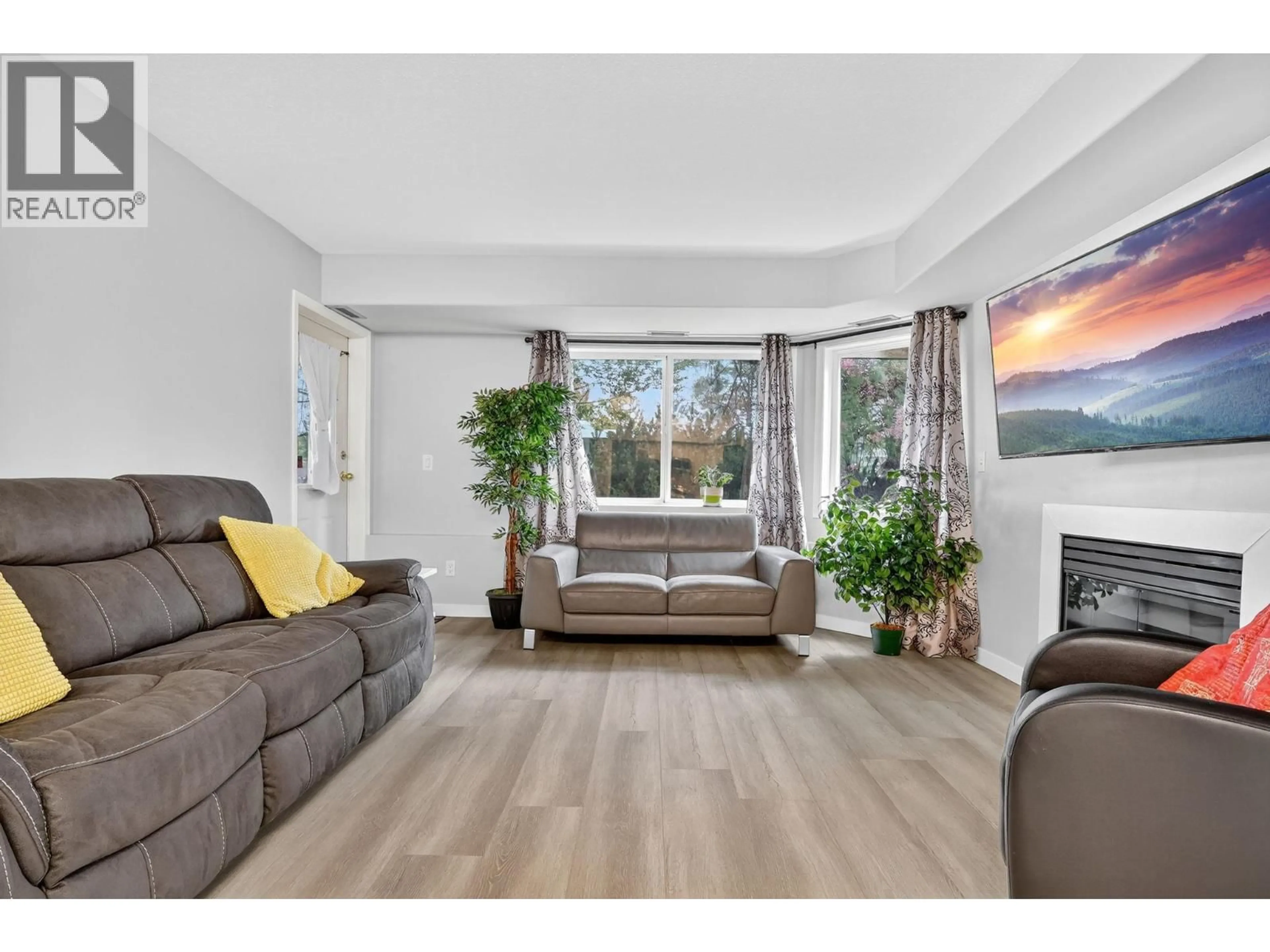Living room with furniture, wood/laminate floor for 105 - 3115 DE MONTREUIL COURT, Kelowna British Columbia V1W3W1