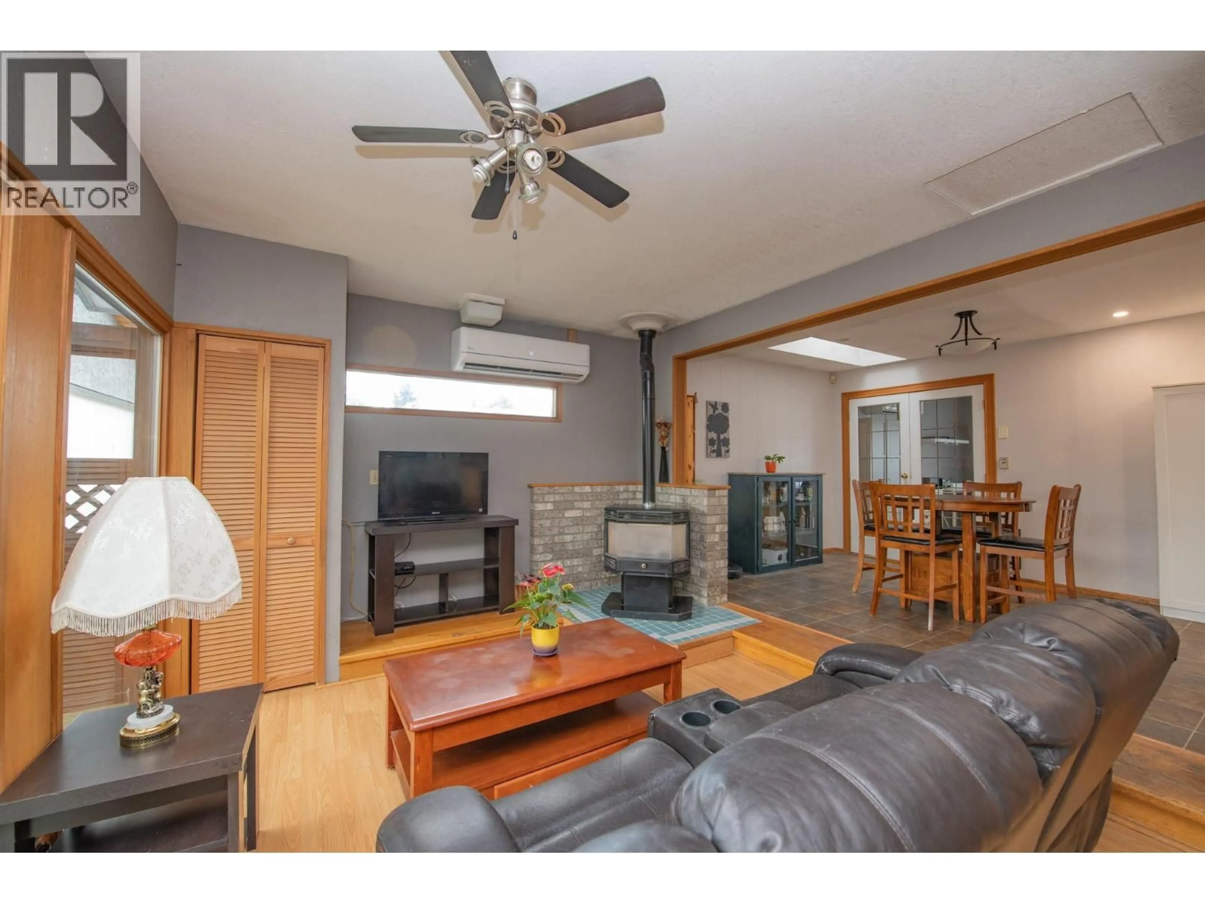 Living room with furniture, wood/laminate floor for 1390 CORNWALL ROAD, Kelowna British Columbia V1X1N9