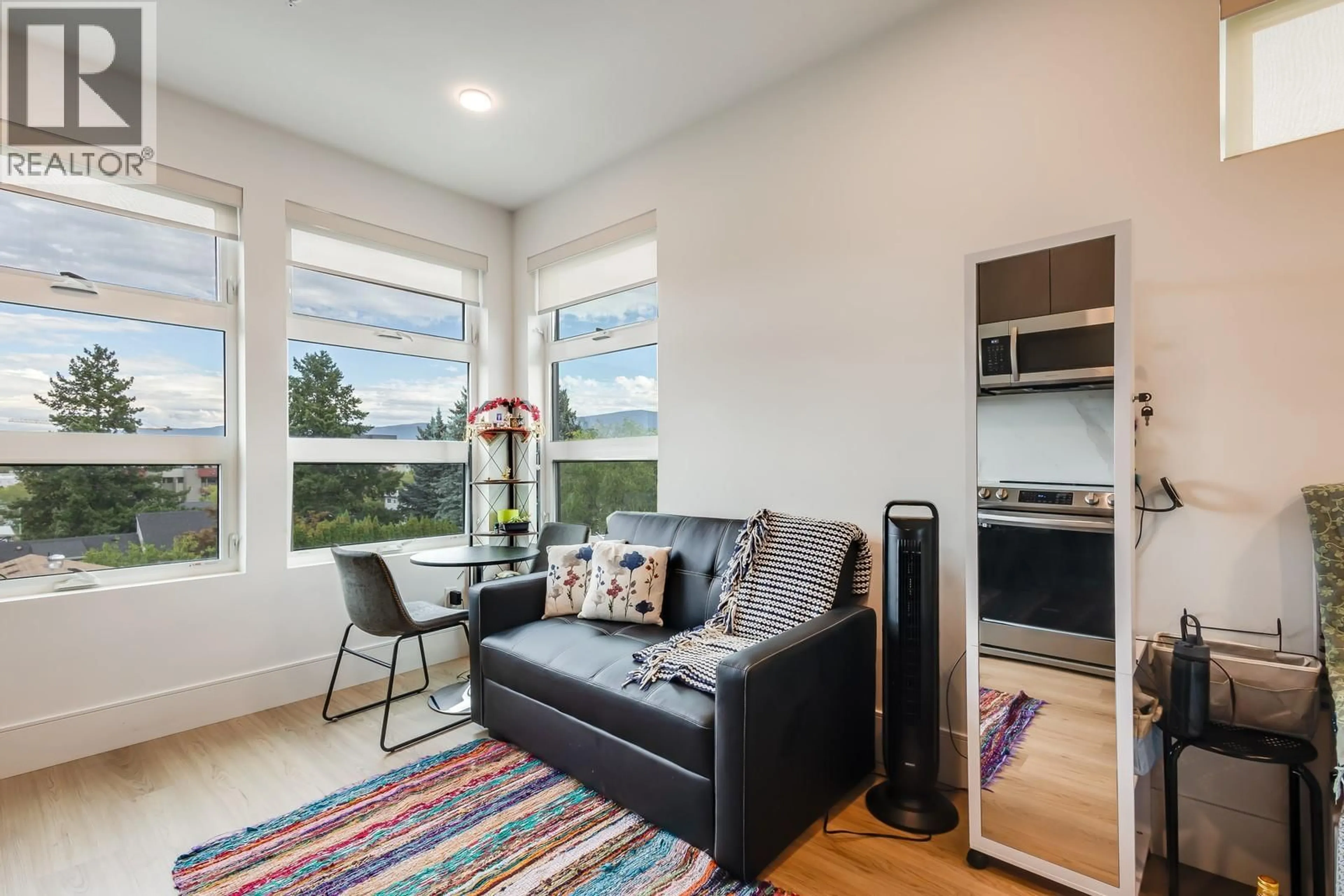 Living room with furniture, wood/laminate floor for 401 - 720 KLO ROAD, Kelowna British Columbia V1Y4X5