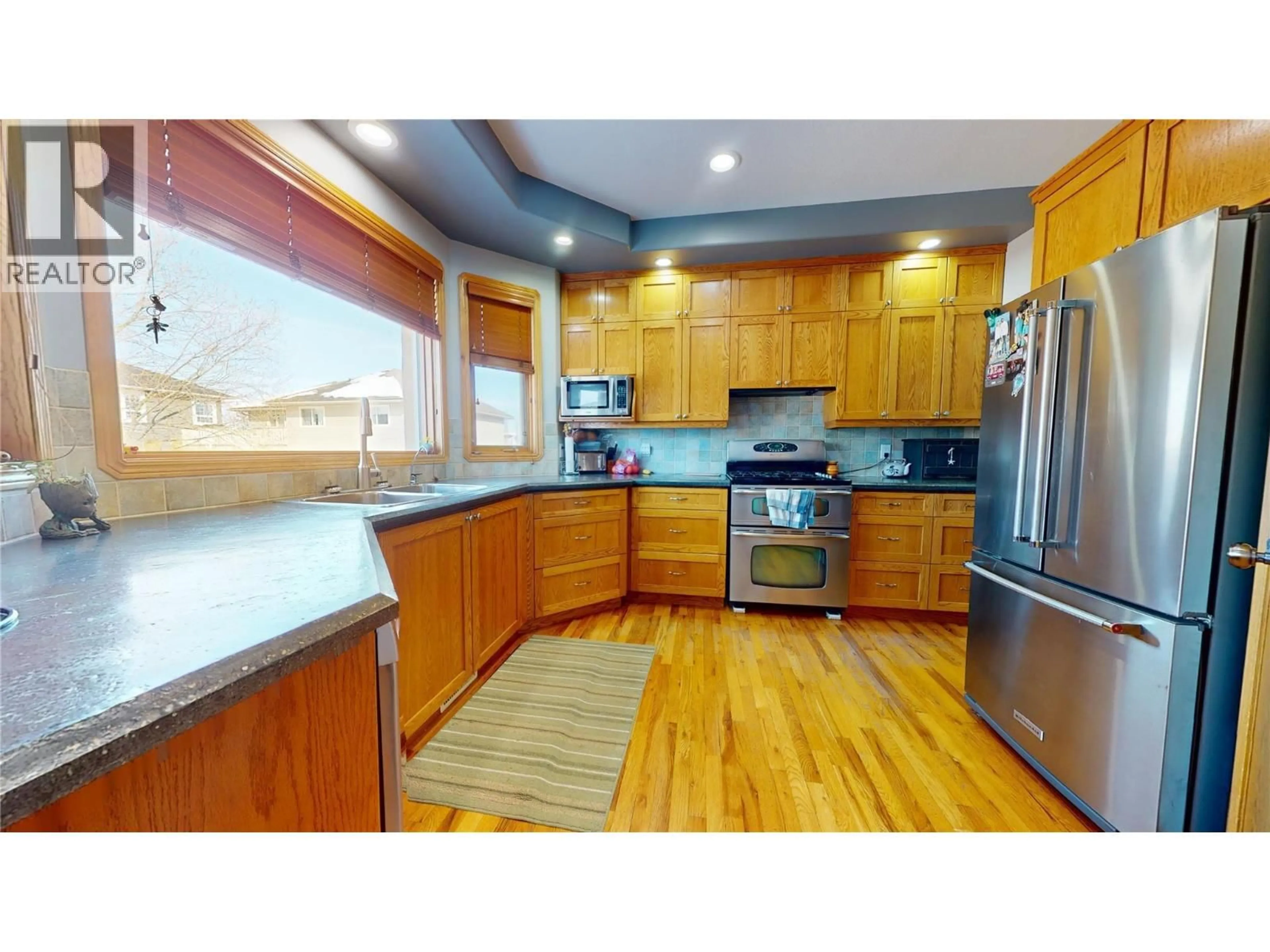 Open concept kitchen, wood/laminate floor for 1340 92 AVENUE, Dawson Creek British Columbia V1G1C3