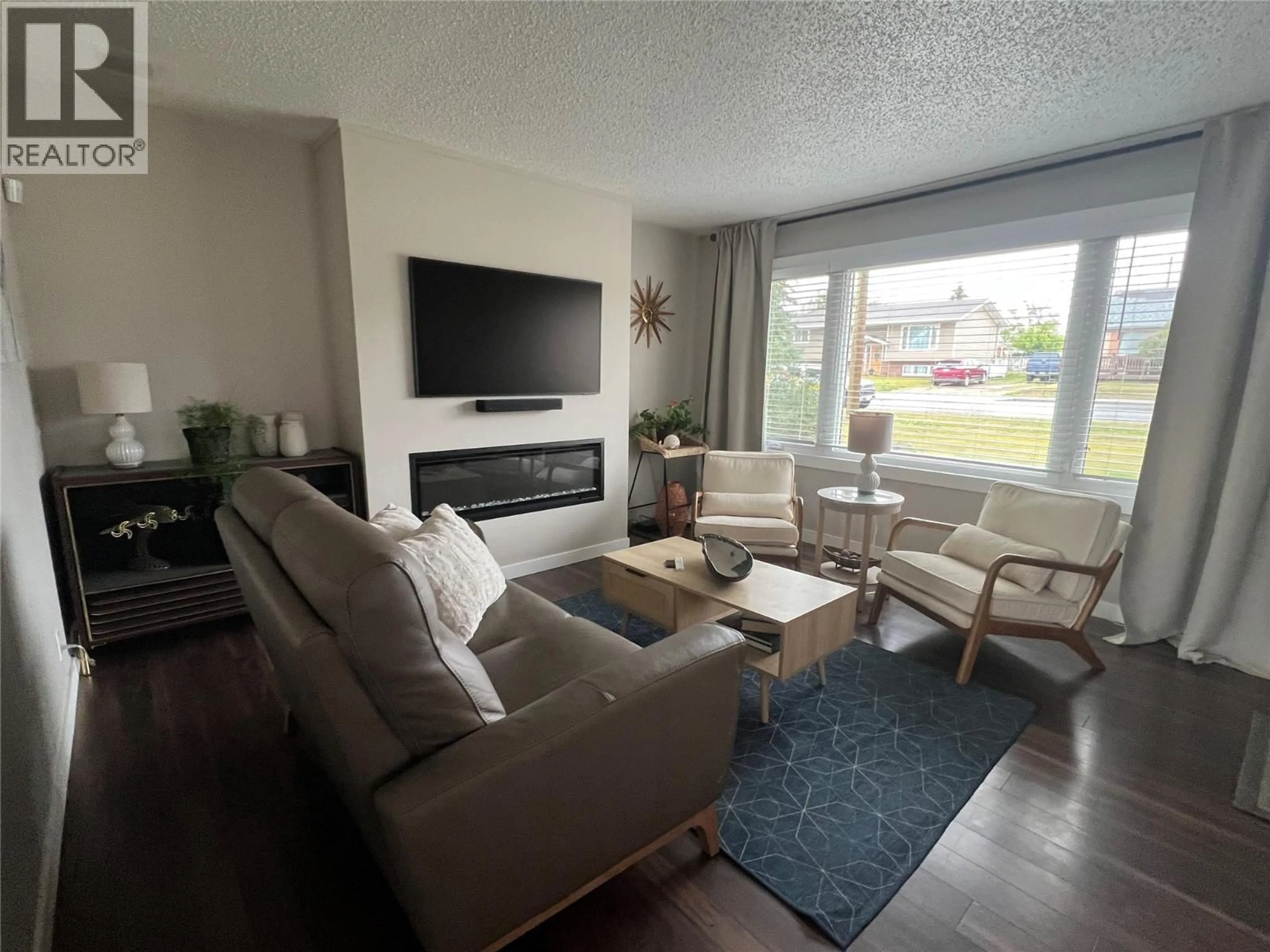 Living room with furniture, wood/laminate floor for 1121 96 AVENUE, Dawson Creek British Columbia V1G1L2