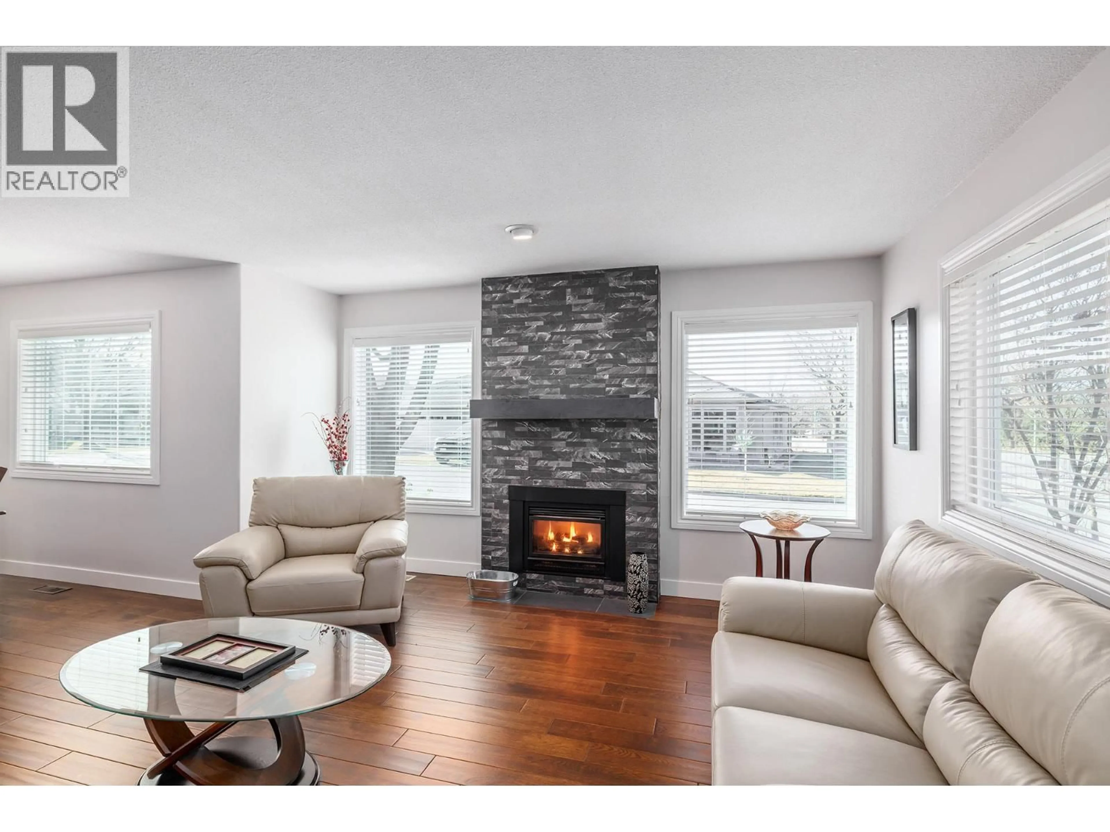 Living room with furniture, wood/laminate floor for 70 - 615 GLENMEADOWS ROAD, Kelowna British Columbia V1V1N9