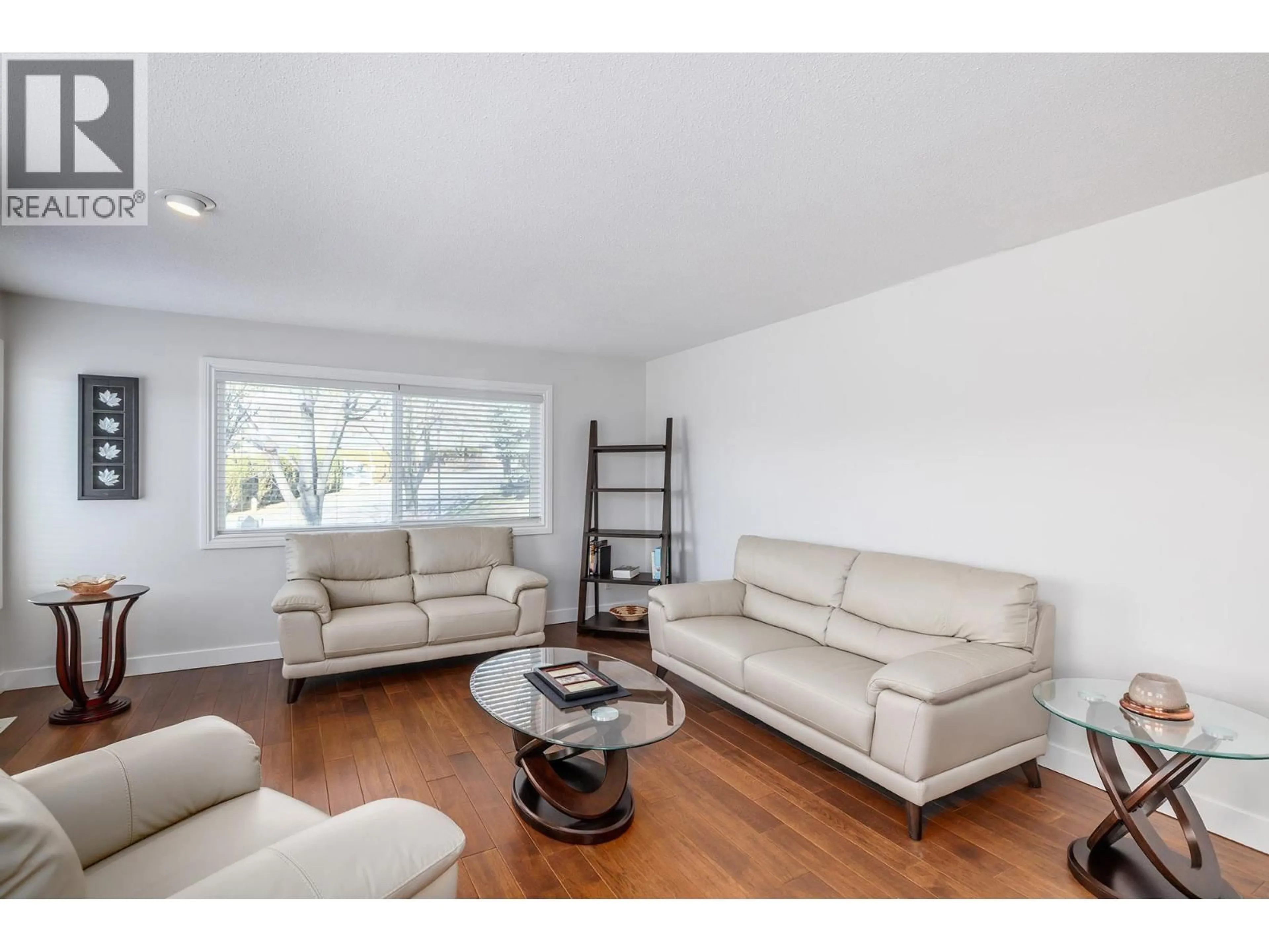 Living room with furniture, wood/laminate floor for 70 - 615 GLENMEADOWS ROAD, Kelowna British Columbia V1V1N9