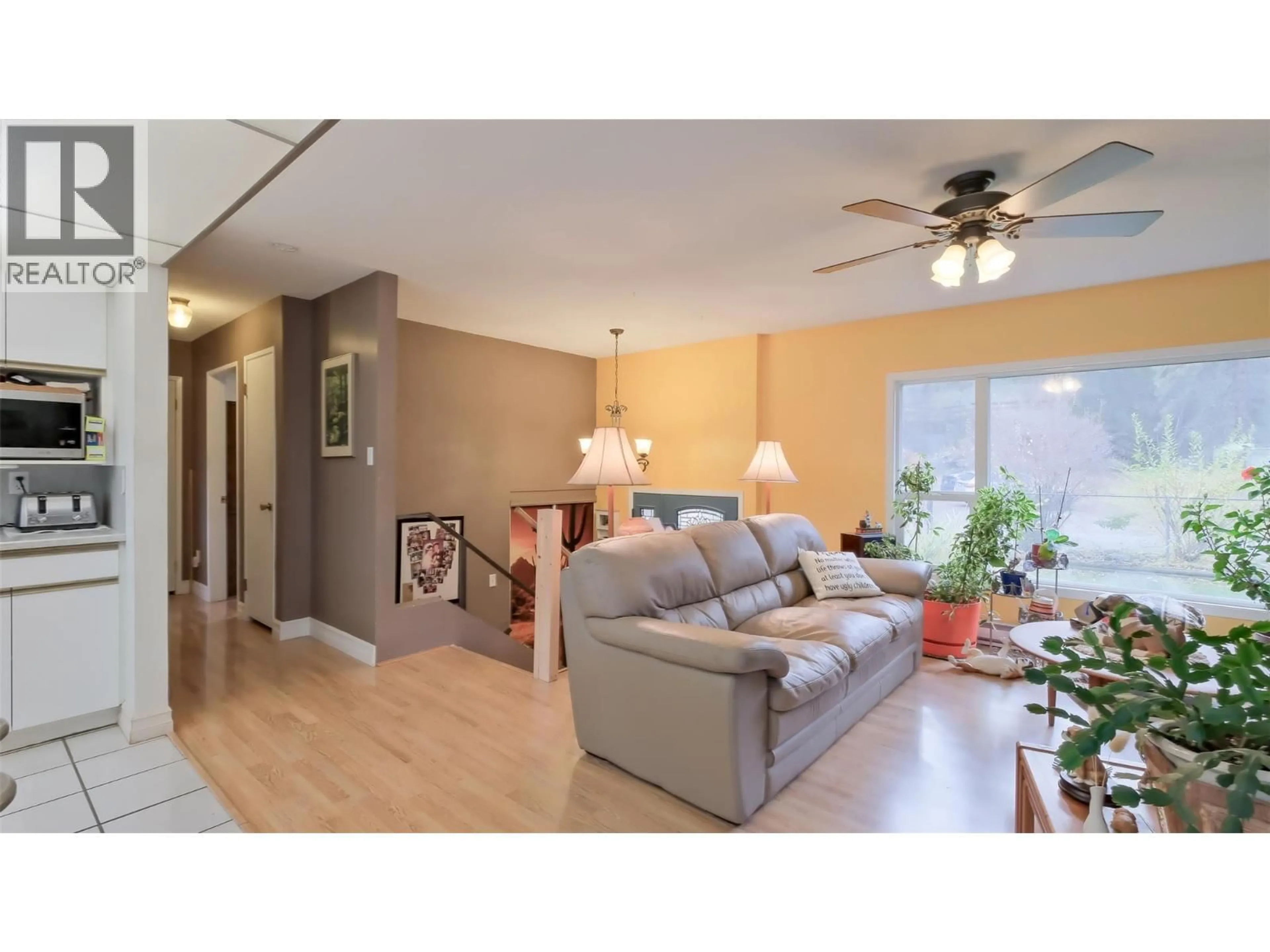Living room with furniture, wood/laminate floor for 4099 MILLER ROAD, Kelowna British Columbia V1W4C7